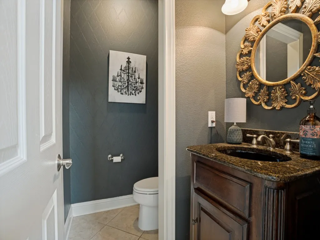 Stylish first-floor powder bath with granite countertop and furniture-style vanity, conveniently located near the main living and entertaining spaces.