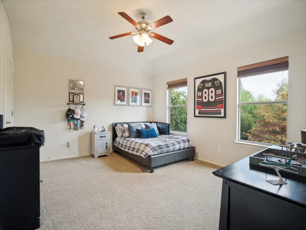 Generously sized upstairs secondary bedroom with tall ceilings, walk-in closet and large windows overlooking the mature trees and backyard.