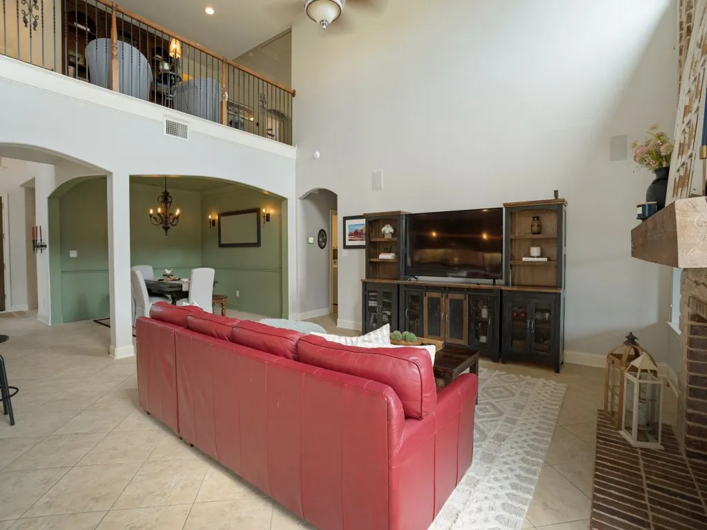 Expansive two-story family room with open sightlines to the formal dining area and upstairs game room, creating an easy flow for everyday living and entertaining.
