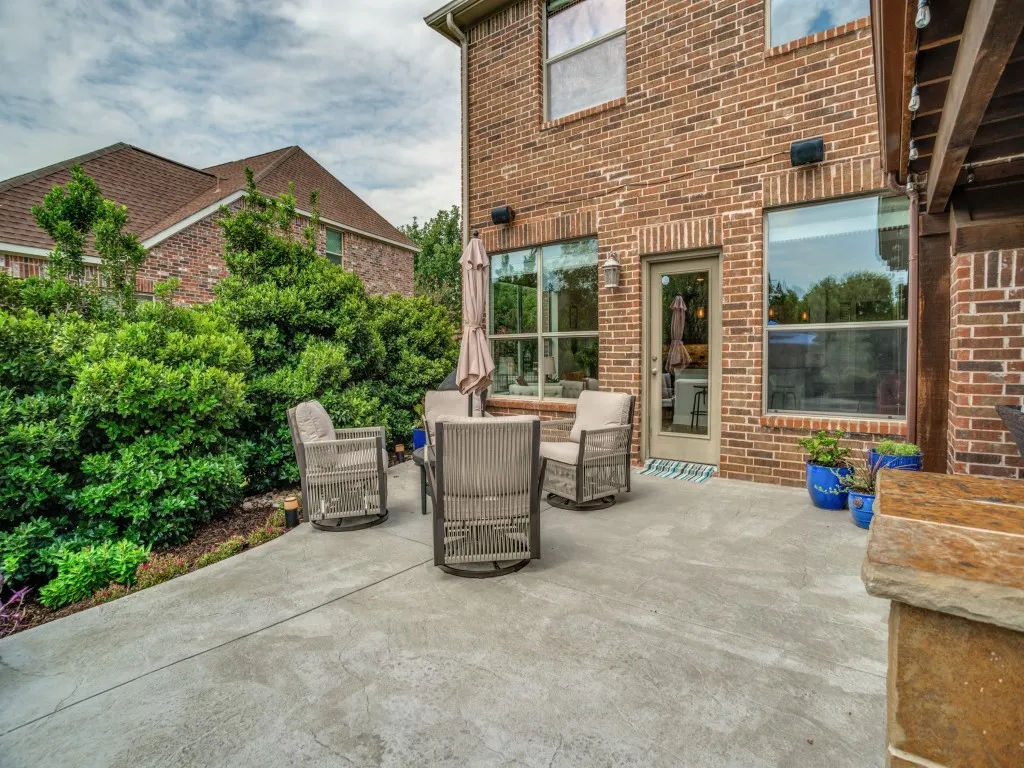 Expansive backyard patio creates another outdoor gathering space surrounded by mature landscaping with convenient access to the kitchen and main living areas.
