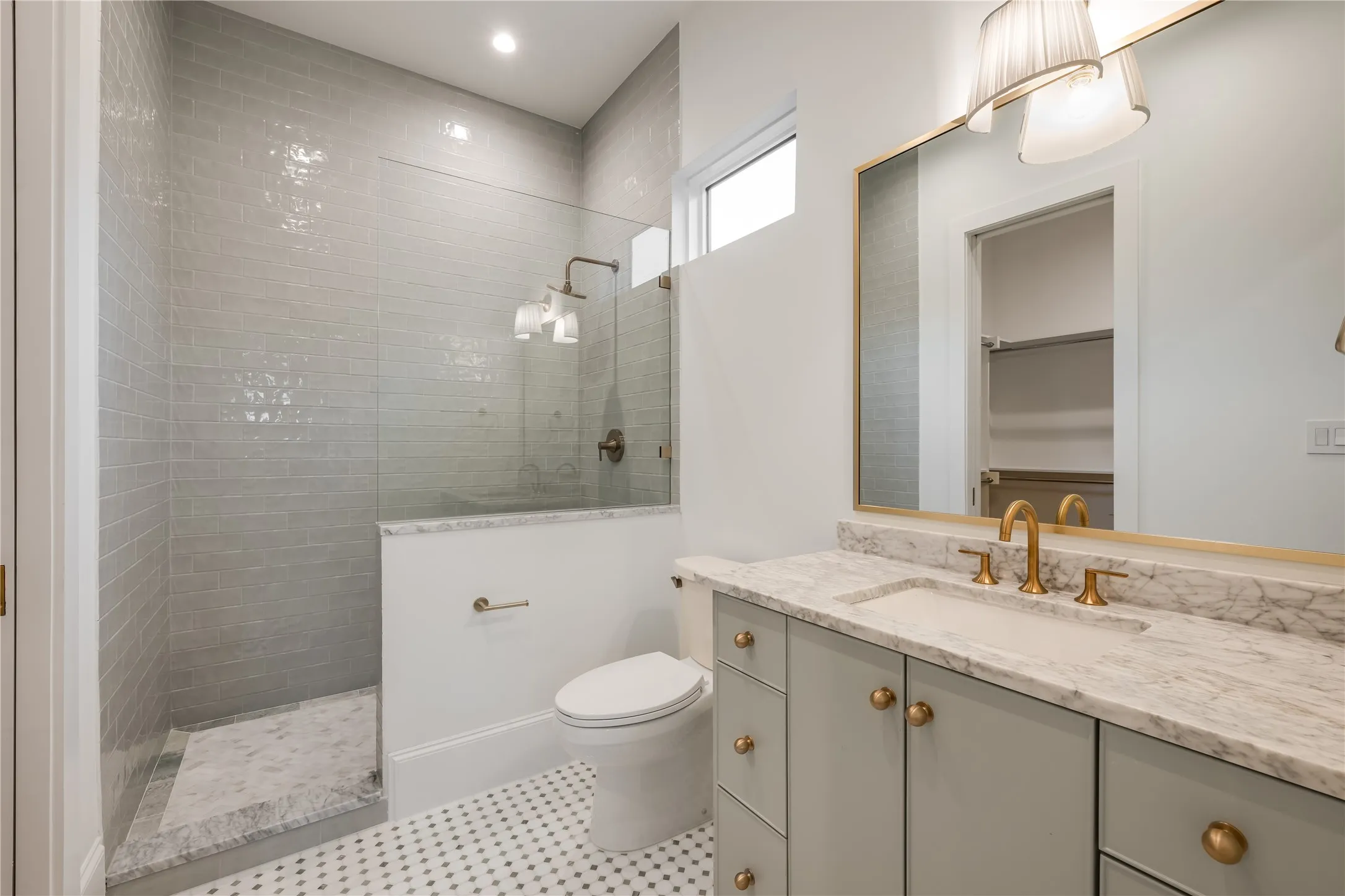 Walk-in shower with subway tile surround, glass enclosure, and mosaic tile flooring