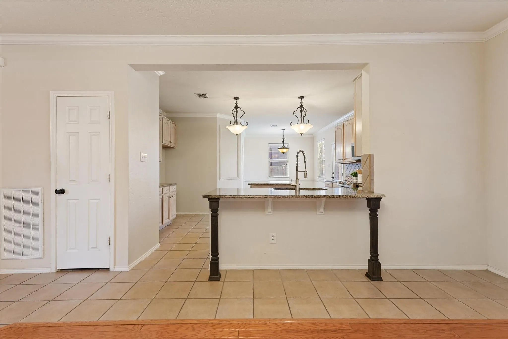 Stone and granite finishes and updated appliances create a custom build appearance to elevate this kitchen design. Just off of the family room, this open concept design is great for entertaining.