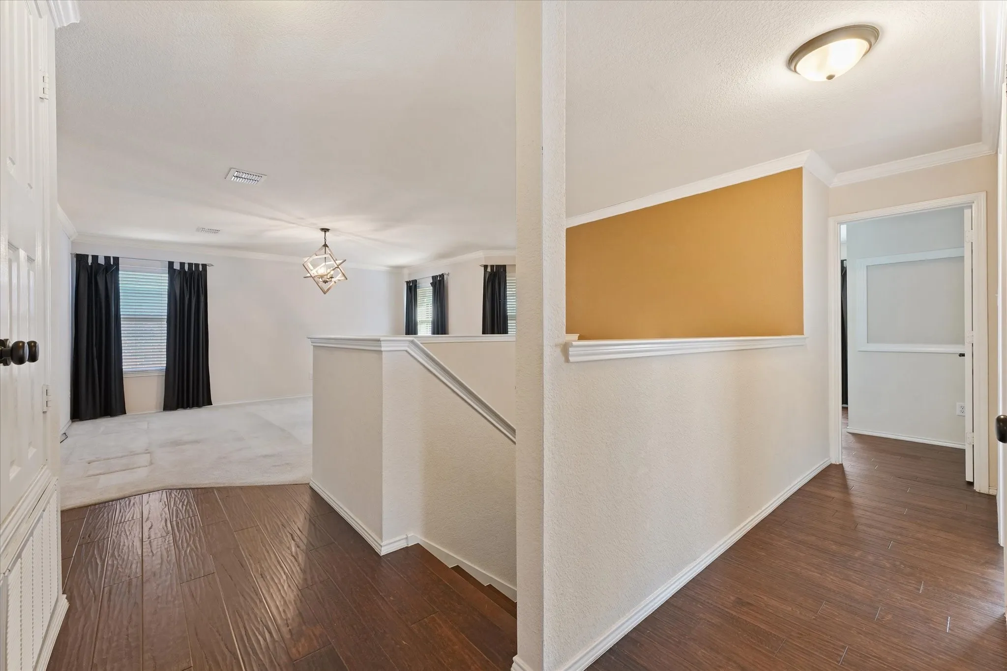 Large, versatile upstairs flex space features carpet and engineered hardwood flooring, decorative light fixture, and recessed lighting, creating an airy, open feel.