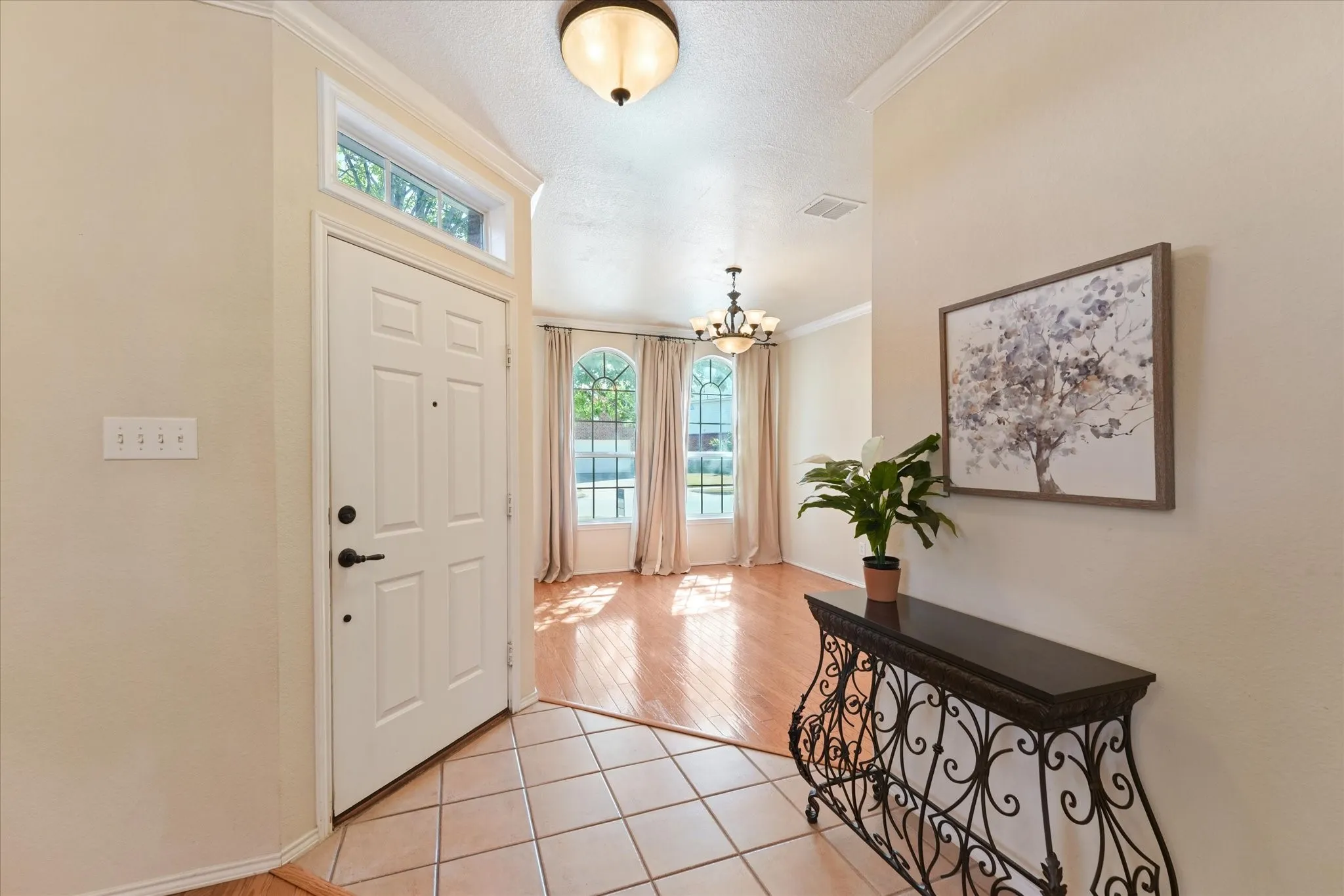 Entryway featuring a decorative front door with transom window and tile flooring, opening into the front flex room that can be an office, play room or formal living. Doors could easily be added to create a private office, if desired.
