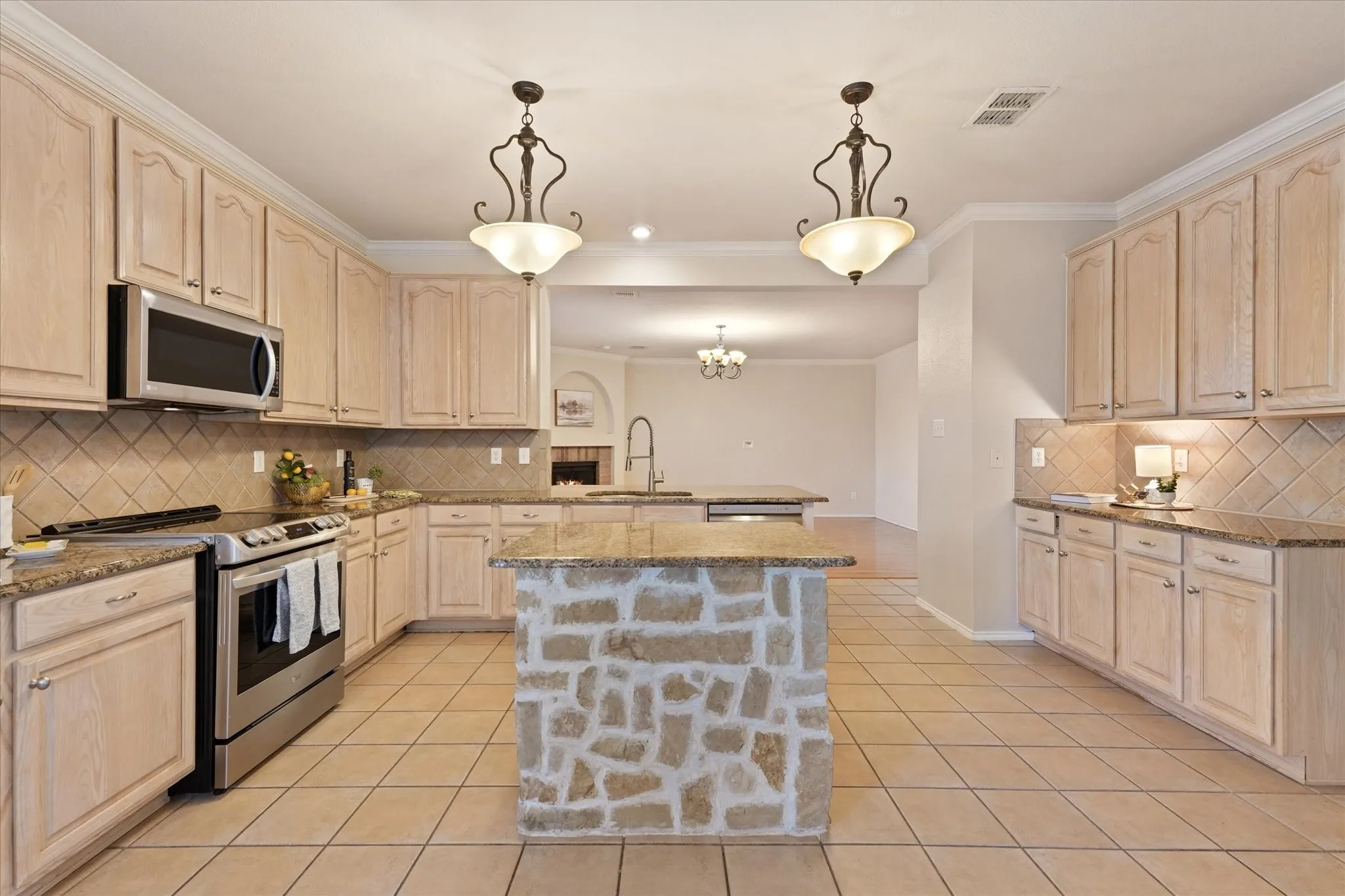 Stone and granite finishes and updated appliances create a custom build appearance to elevate this kitchen design. Just off of the family room, this open concept design is great for entertaining.