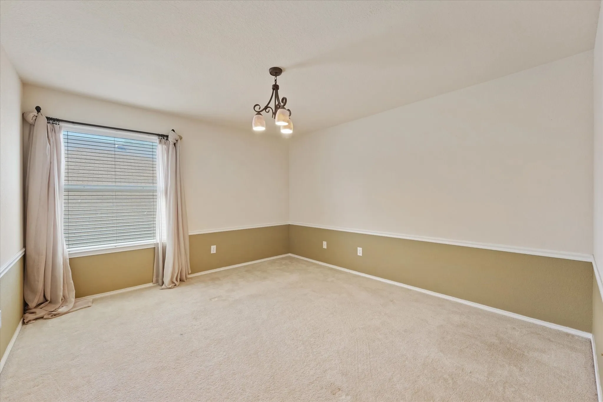 Wall-to-wall carpeting and a two-tone painted wall with chair rail molding