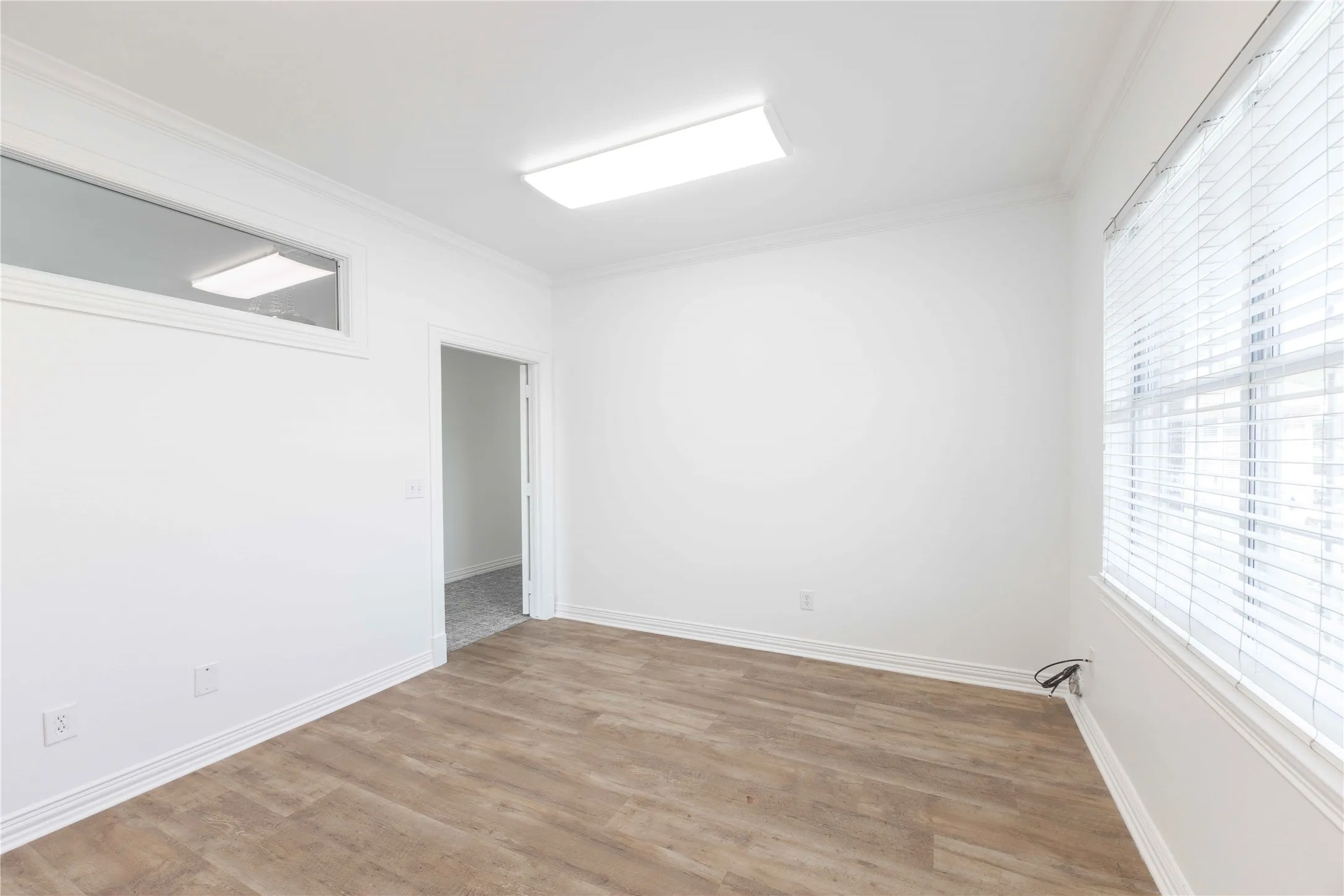 Wood-finish flooring with white baseboards