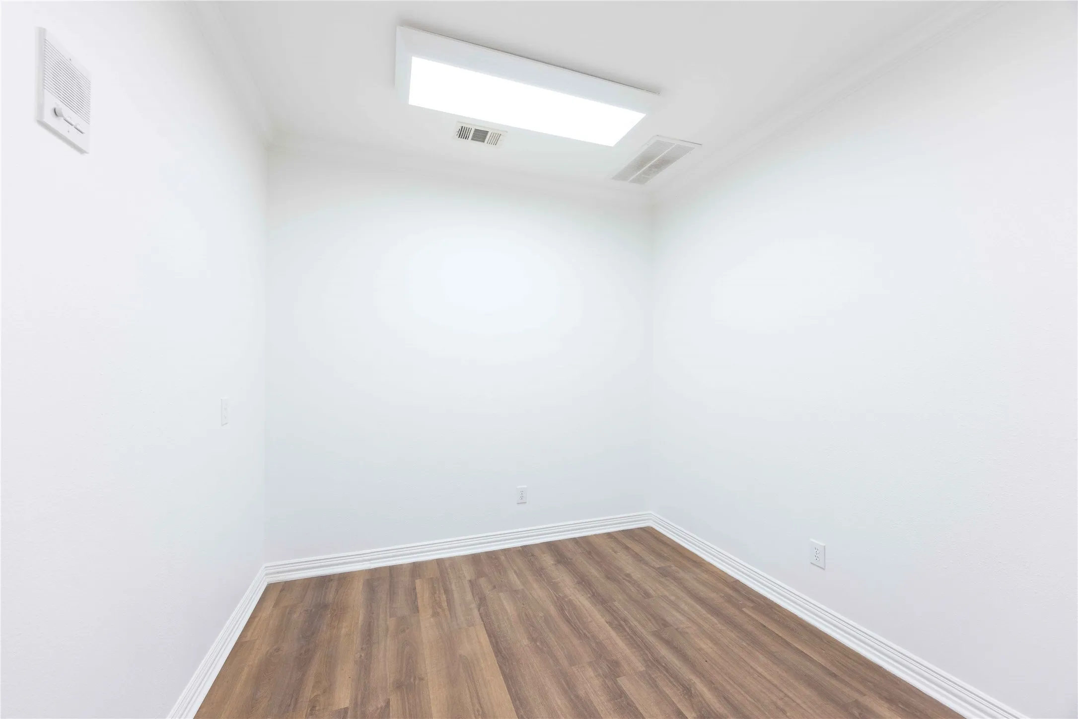 Recessed lighting, crown molding, wood-finish flooring, white walls, and white trim