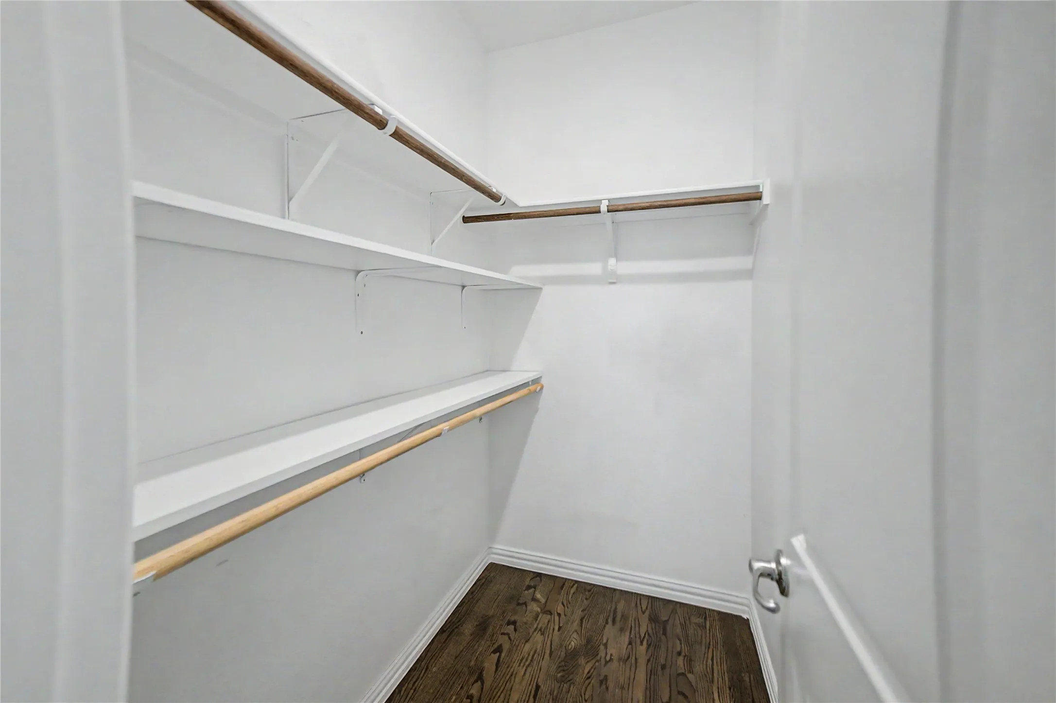 Walk-in closet with multiple shelving units and hanging rods