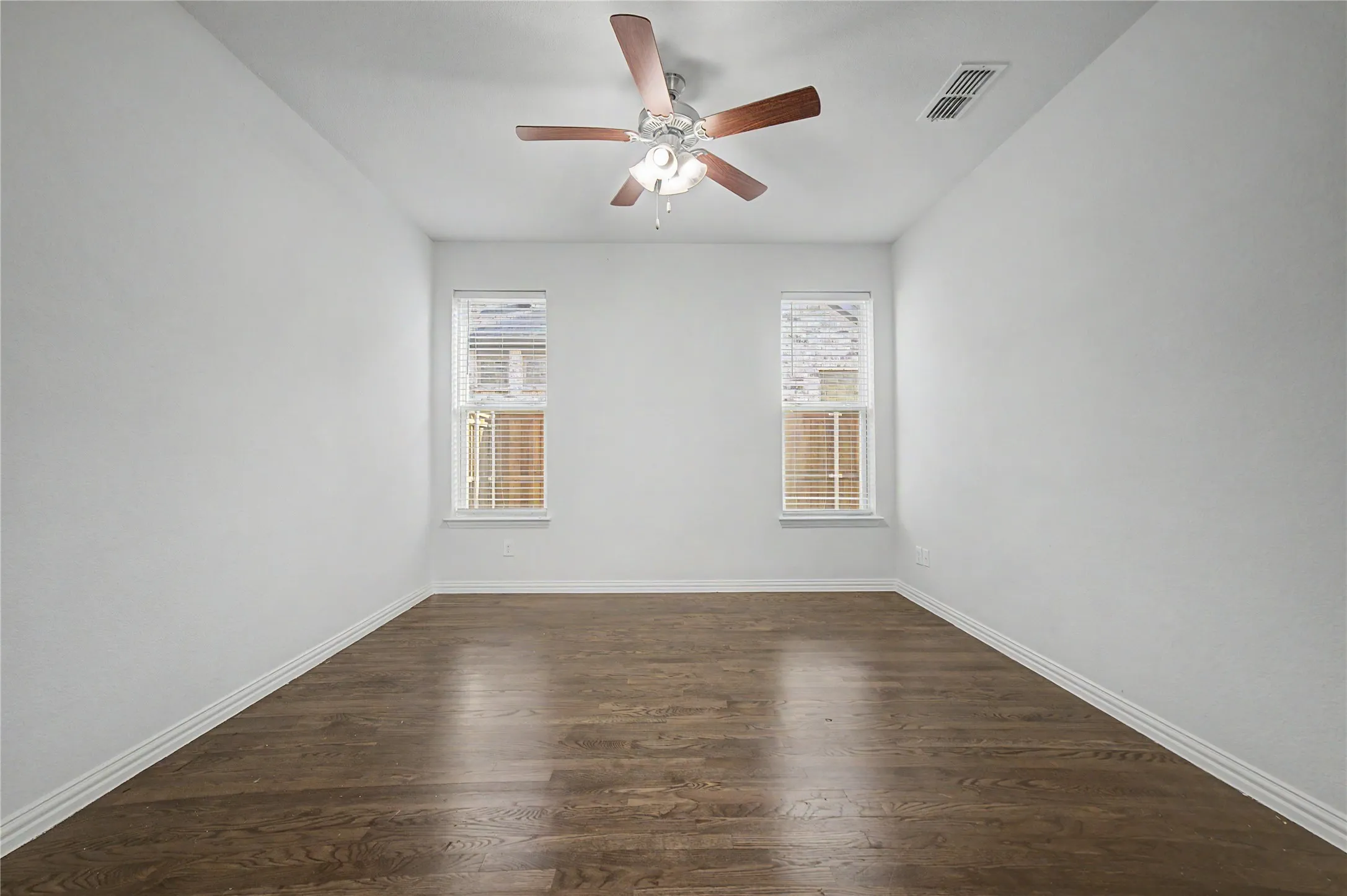 Recessed lighting, ceiling fan with light kit, wood-finish flooring, two windows with blinds, and white painted walls