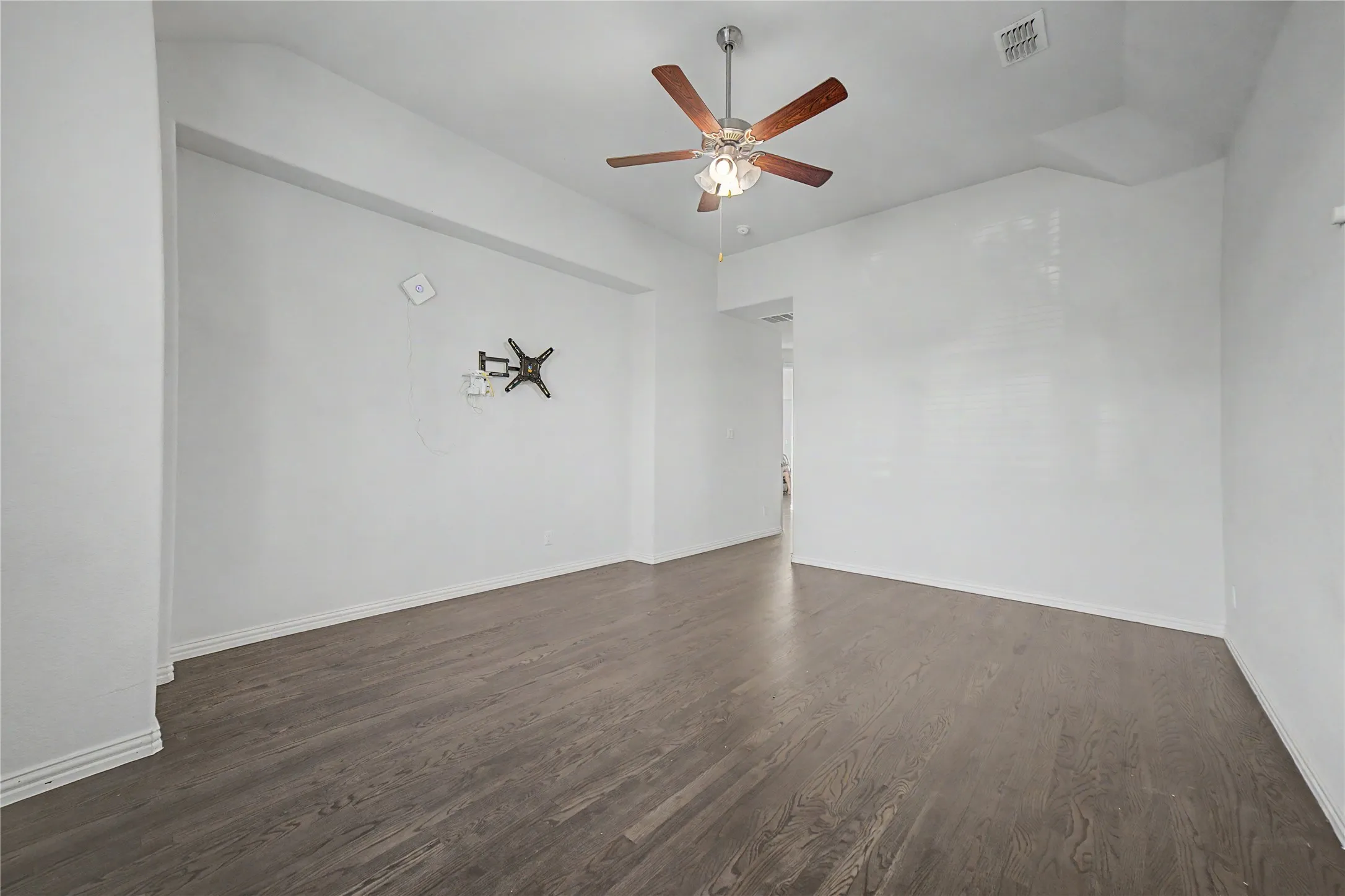 Wood-finish flooring throughout, complemented by a ceiling fan with integrated lighting