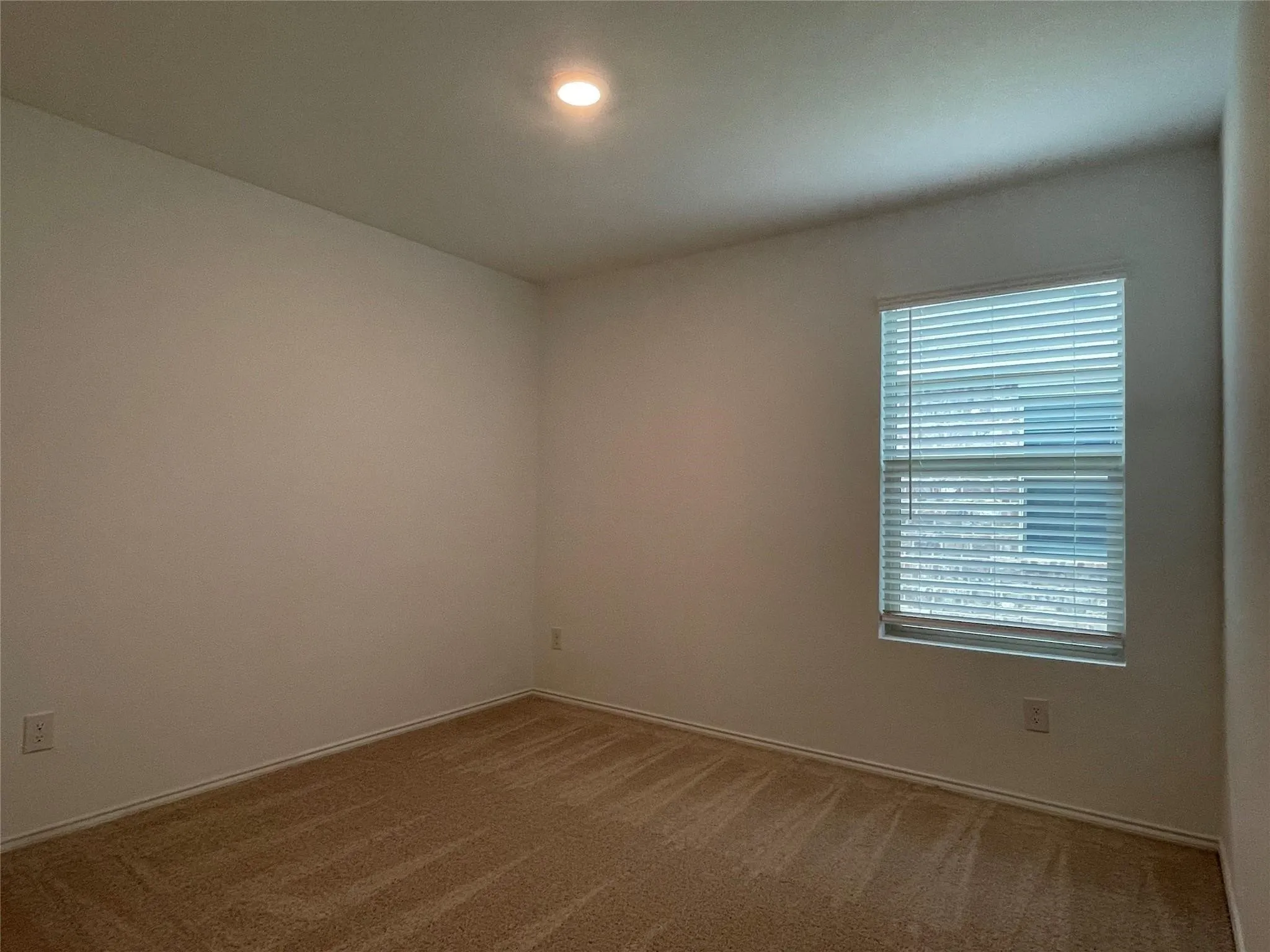 Neutral wall paint, recessed lighting, window with blinds, and carpeting