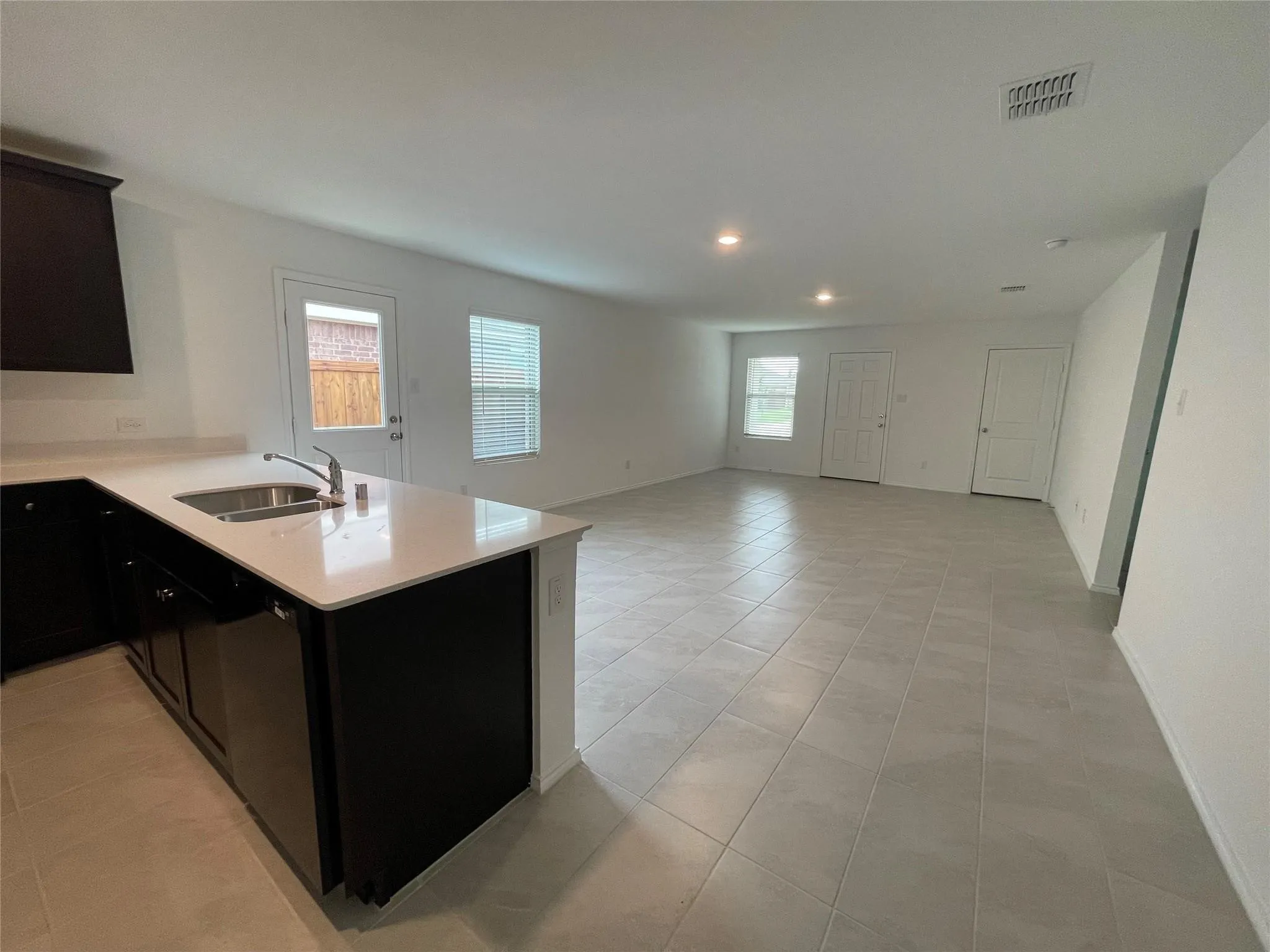 Open-concept living area with light-toned tile flooring