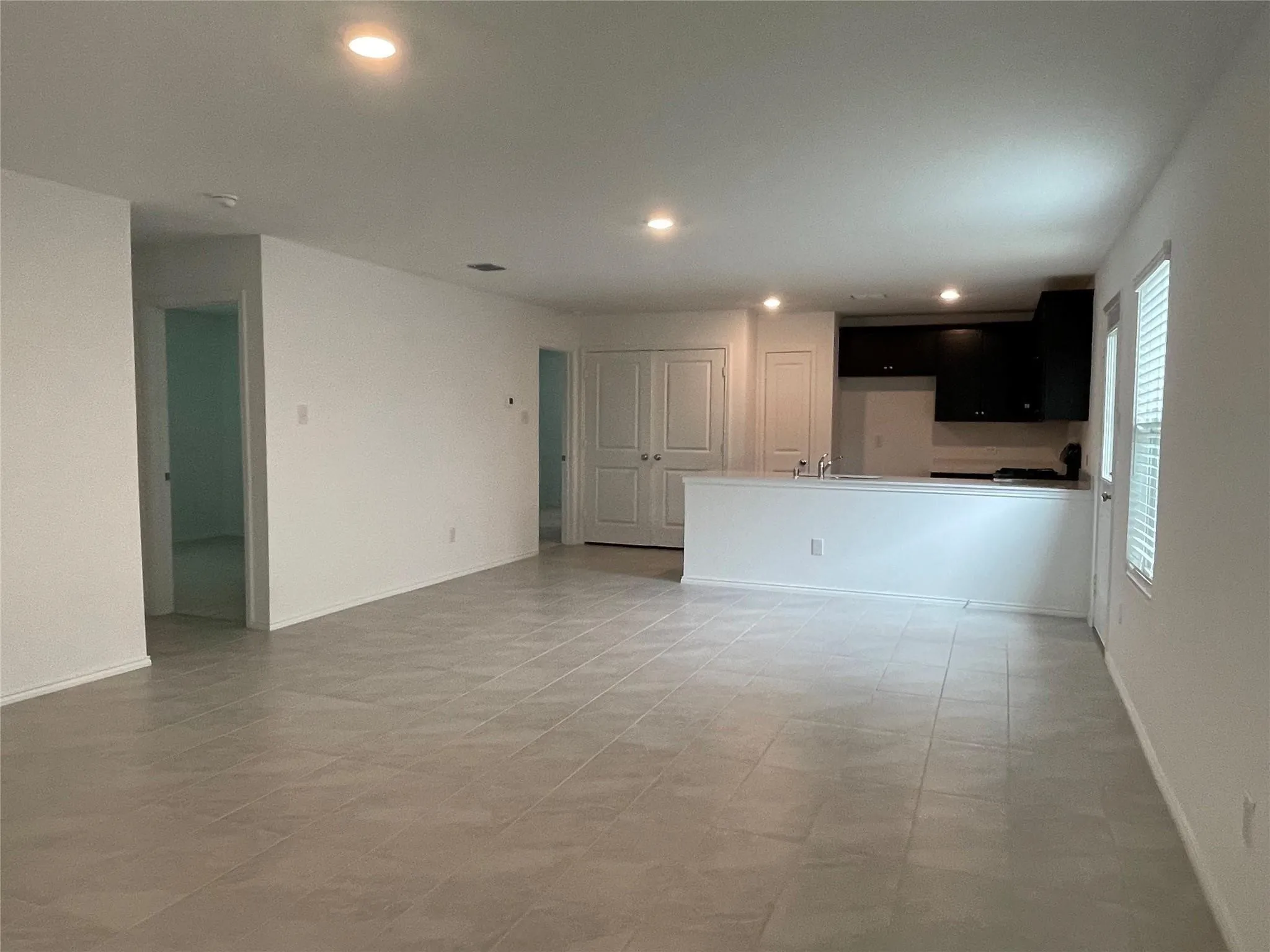 Open-concept living area with tile flooring and recessed lighting