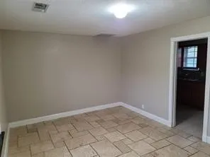 Neutral tone wall paint, tile flooring, white trim, recessed ceiling light, and interior doorway