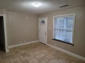 Tiled flooring, white trim, and a window with blinds