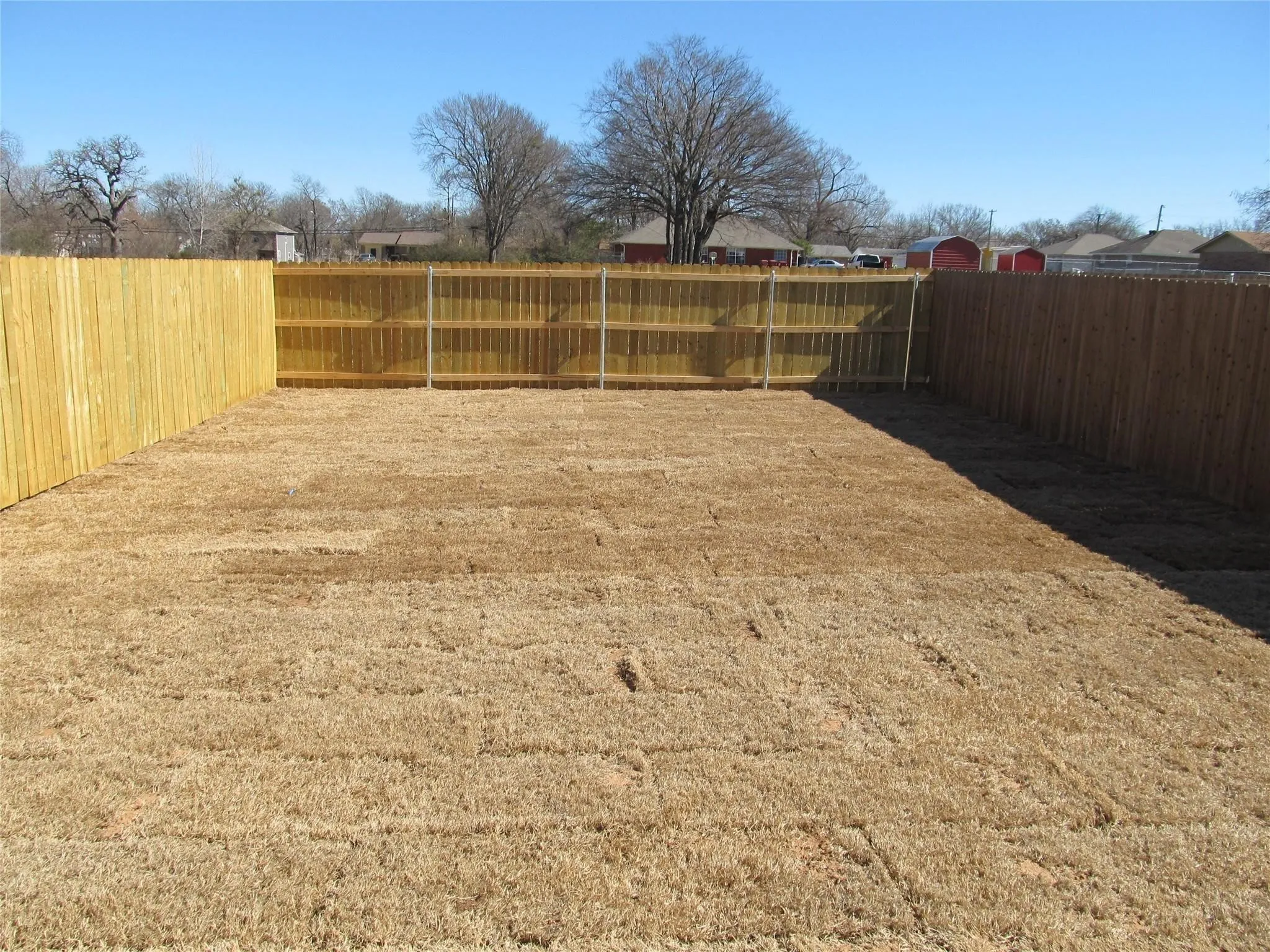 Expansive yard area featuring a combination privacy fence, a wood-panel fence, and a chain-link fence