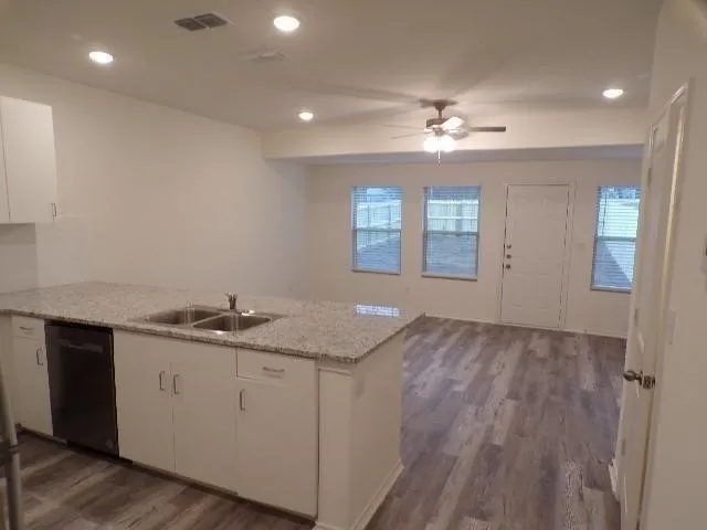 Kitchen island with granite countertop, stainless steel double sink, and integrated dishwasher