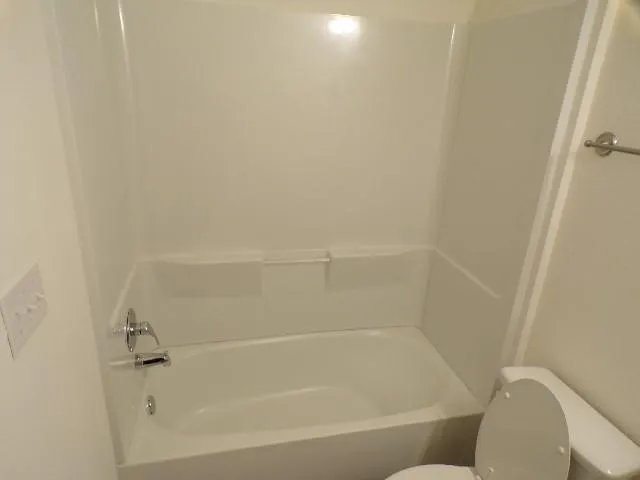 White tub and shower combination with chrome fixtures