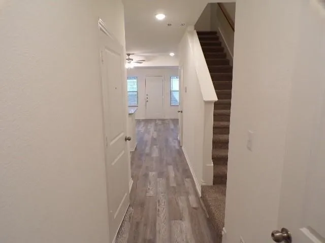 Wood-finish flooring, recessed lighting, and a staircase with carpeted treads