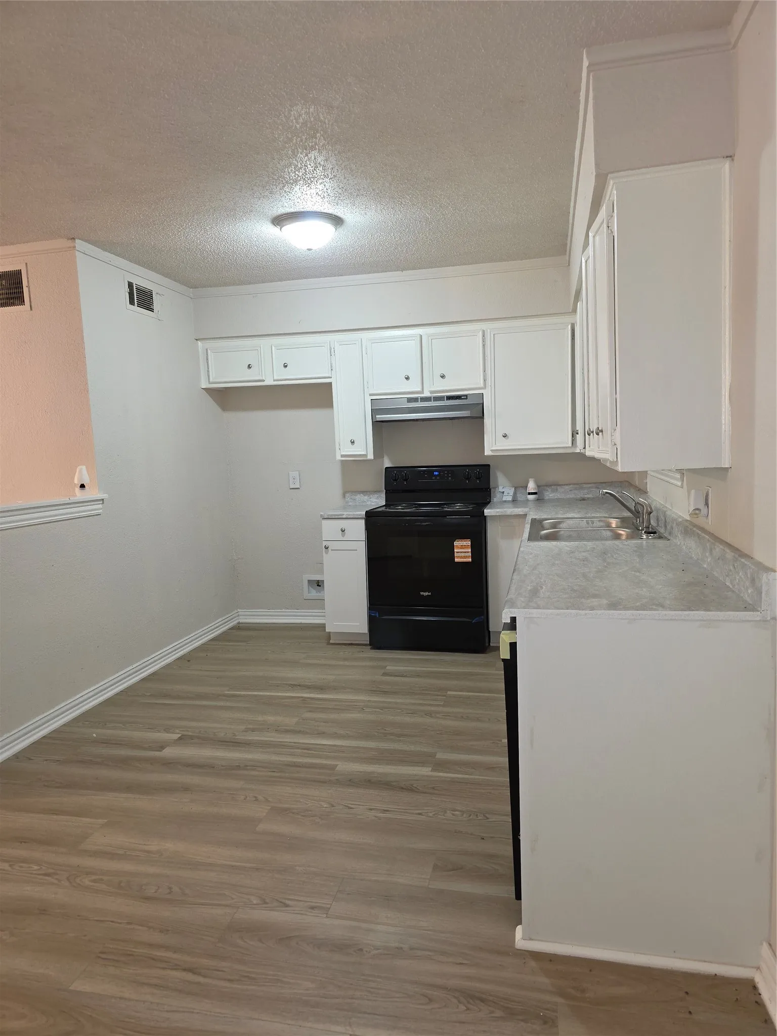Kitchen featuring wood-finish flooring.