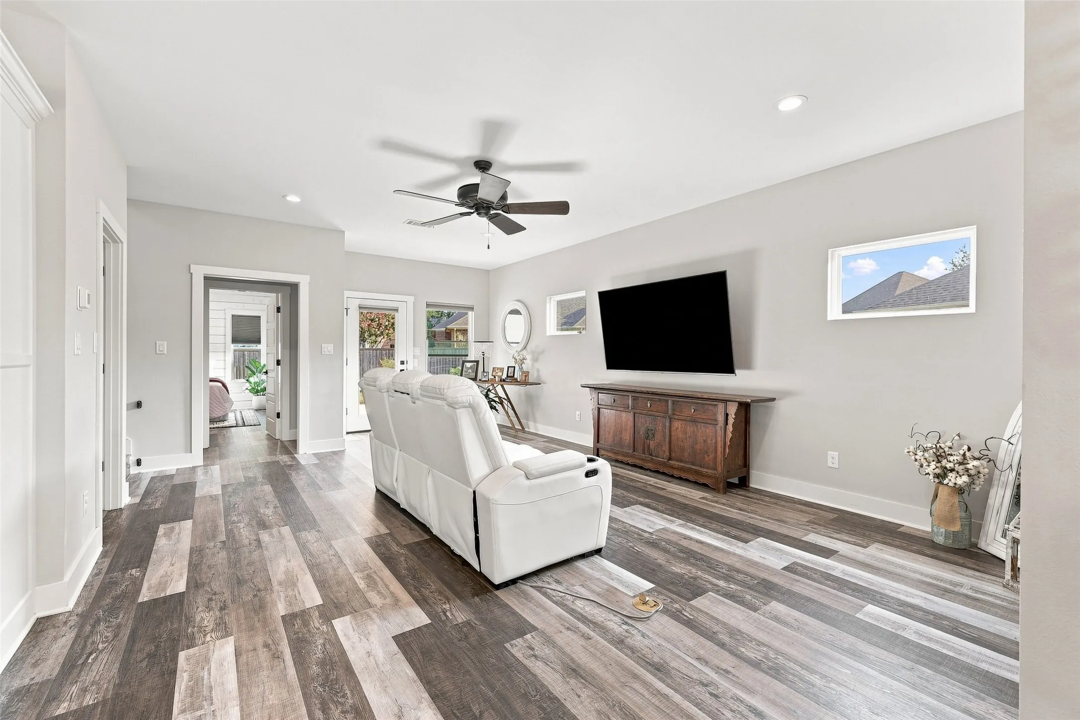 Wood-finish flooring, recessed lighting, ceiling fan, white trim, and a glass-paned door