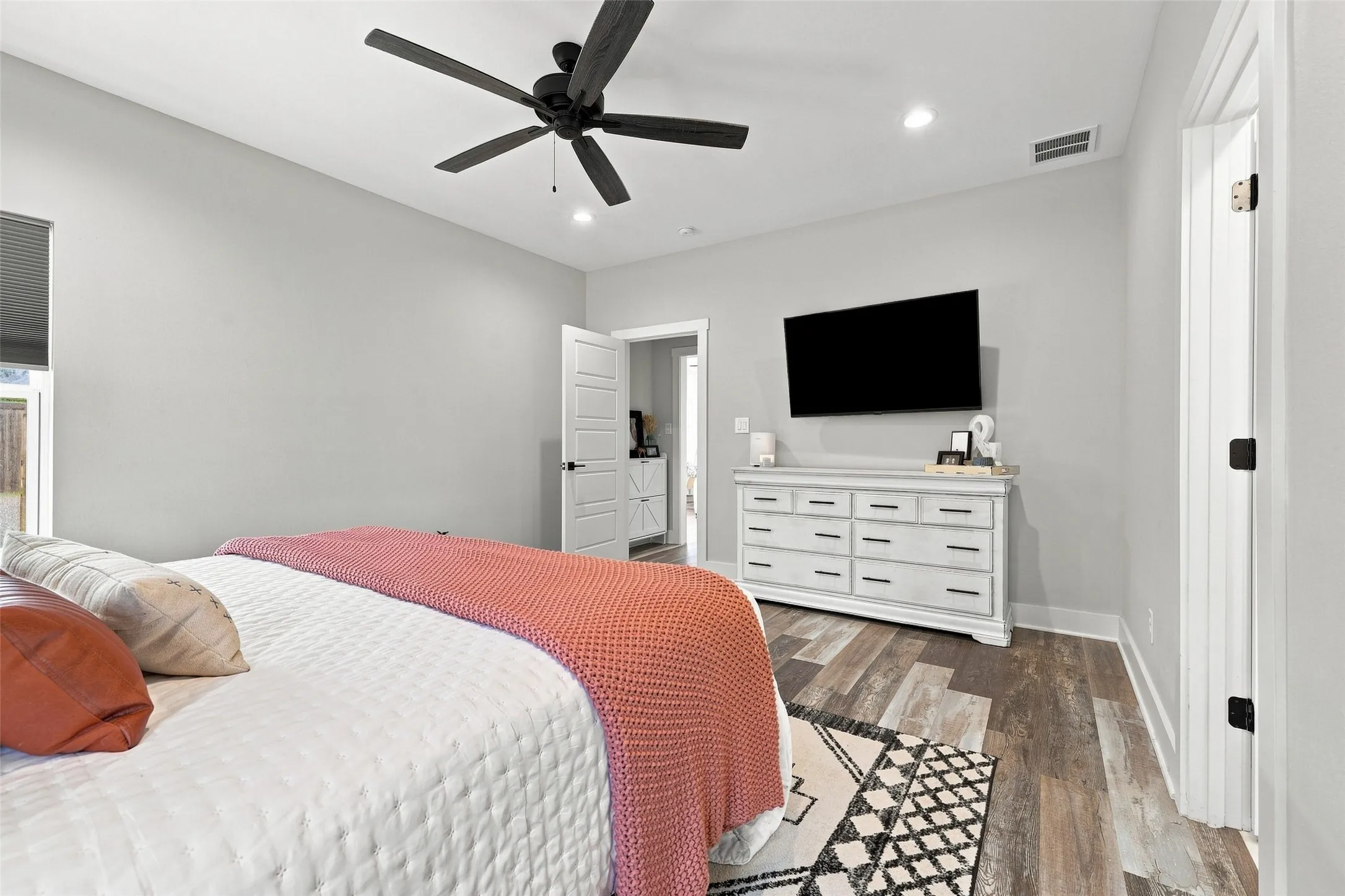 Wood-finish flooring, recessed lighting, and a contemporary ceiling fan