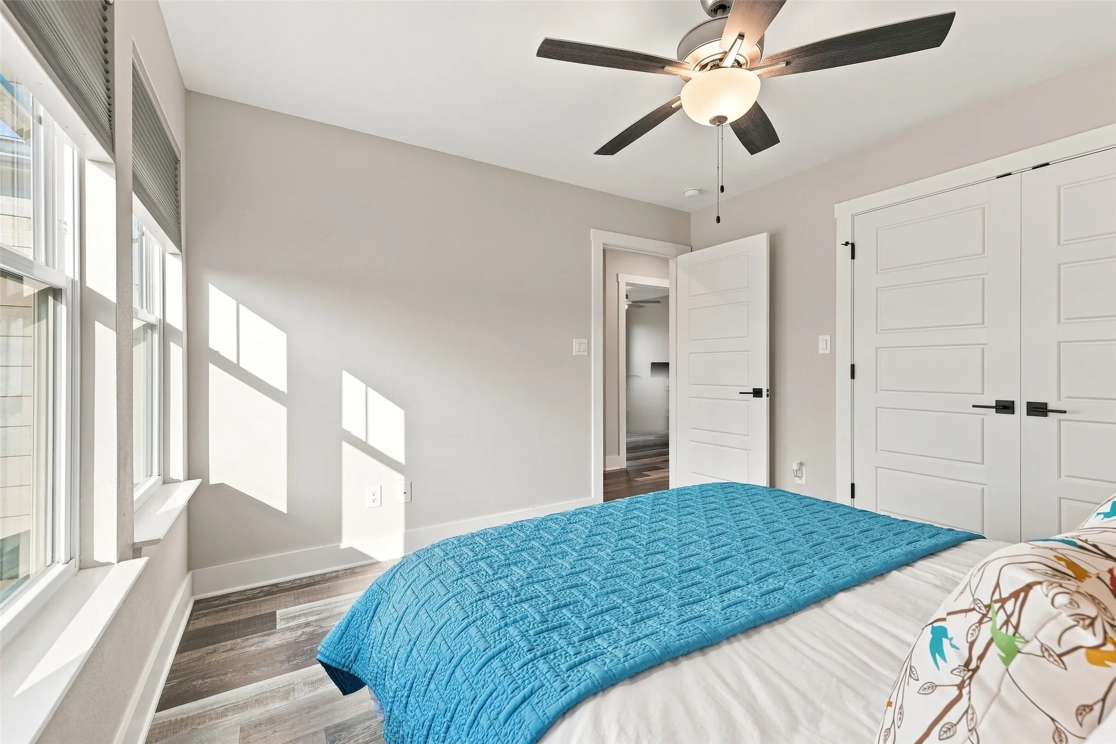 Wide windows, wood-finish flooring, ceiling fan, contemporary doors, and modern hardware
