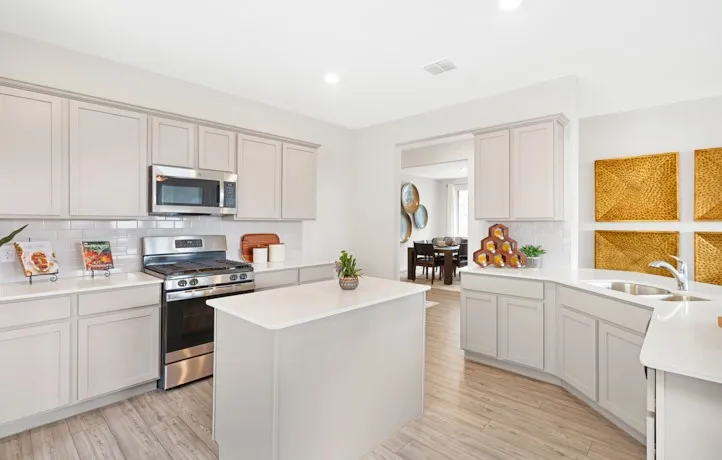 Modern kitchen featuring light cabinetry, a central island, and stainless steel appliances