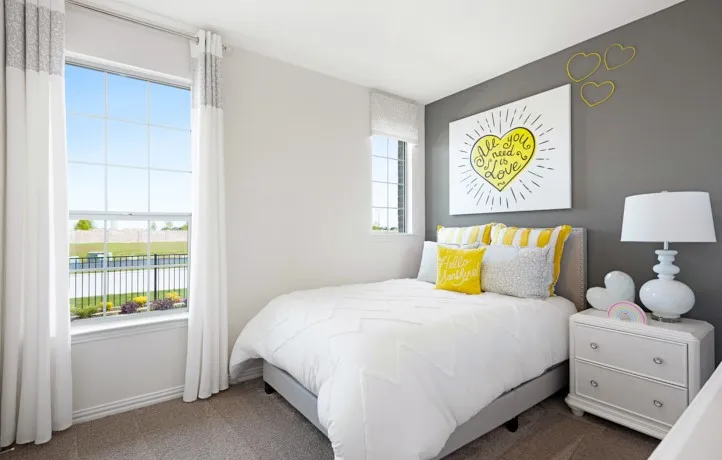 Bedroom featuring carpet flooring, two windows with blinds and curtains, and a two-tone wall finish