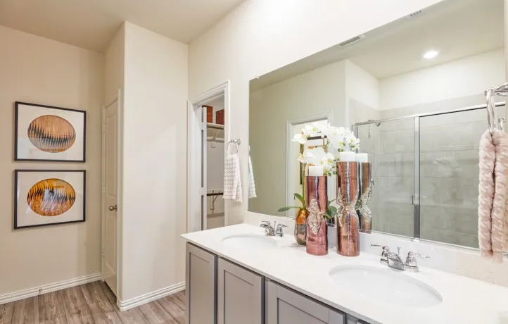 Dual vanity with white undermount sinks, chrome fixtures, and a speckled white countertop