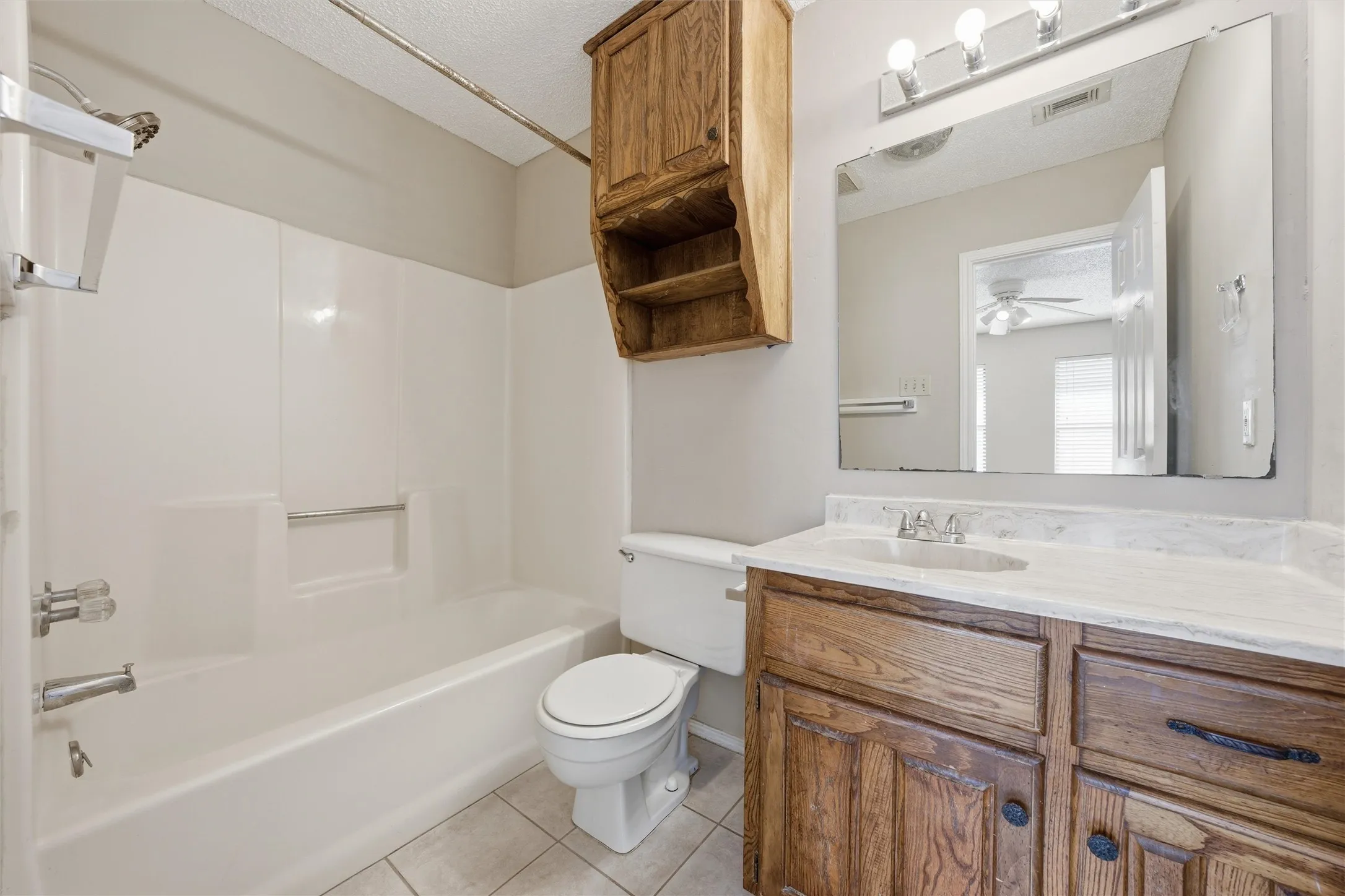 White tub and shower combination with a textured surround