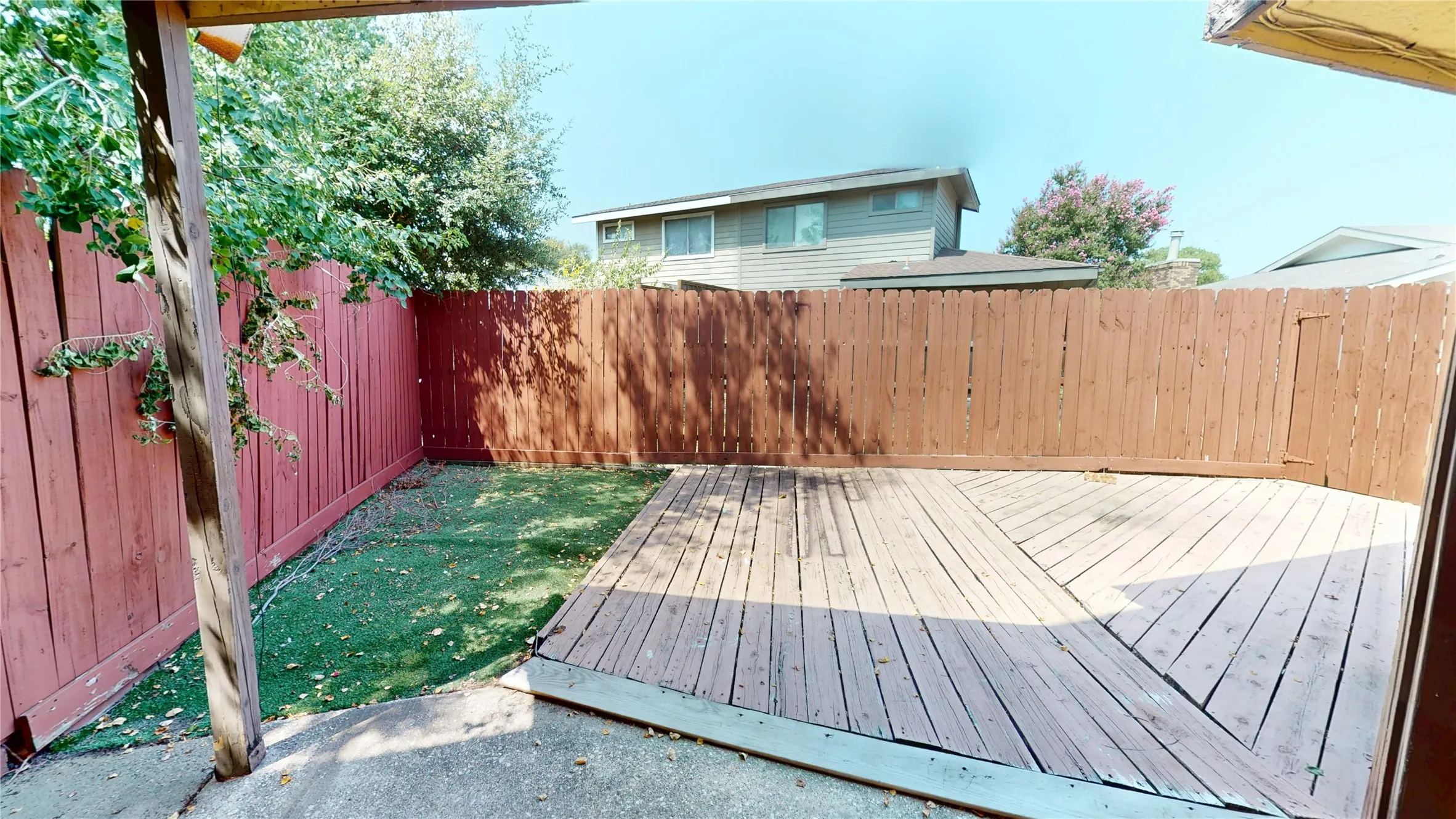 Wood deck with varied plank orientation, artificial turf area, and wood privacy fencing