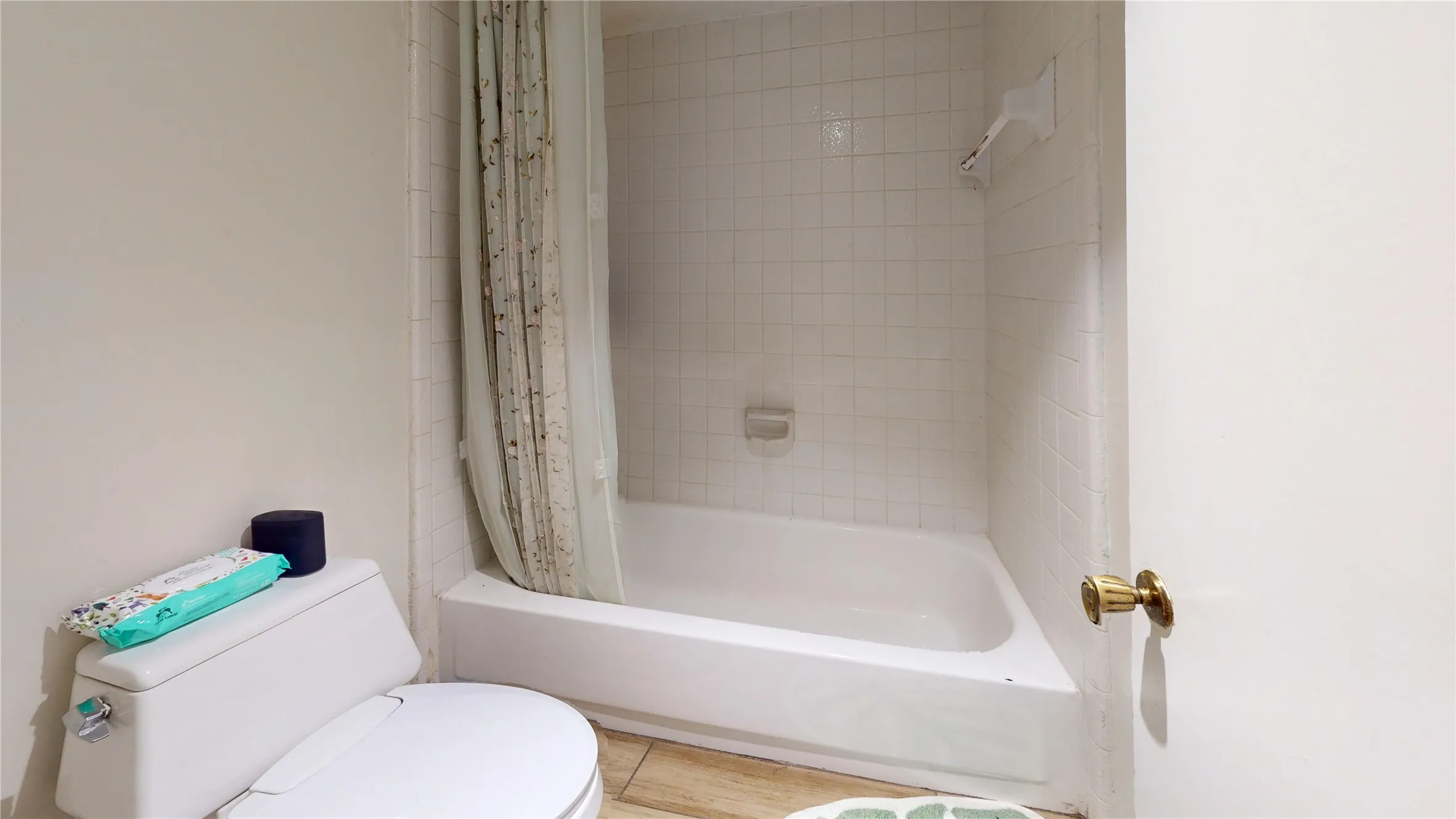 White ceramic bathtub with tiled surround and integrated soap dish