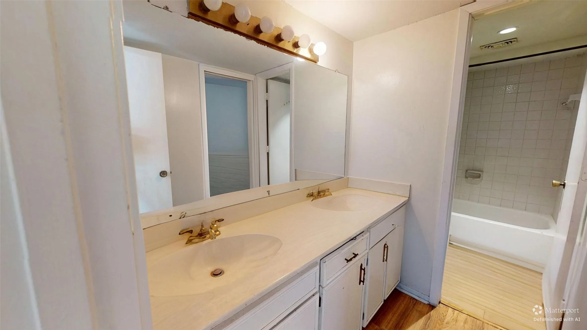 Double vanity with integrated sinks, brass-finish faucets, and a white countertop