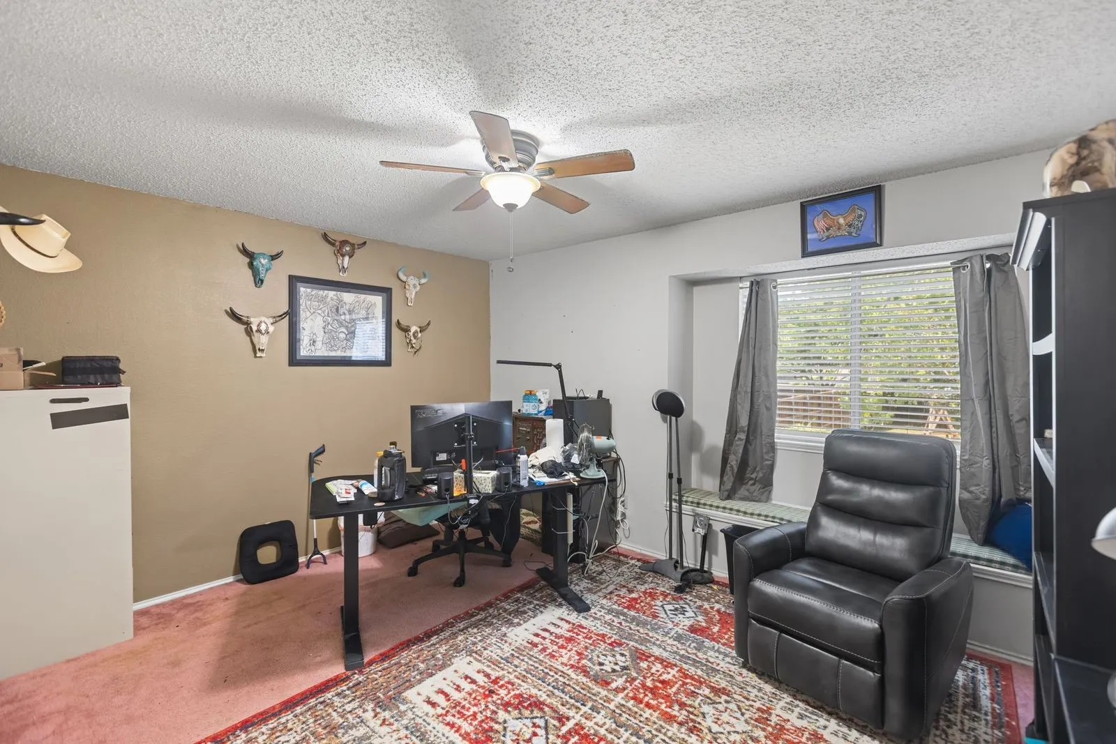 Recessed window with a built-in window seat, ceiling fan, textured ceiling, and mixed flooring