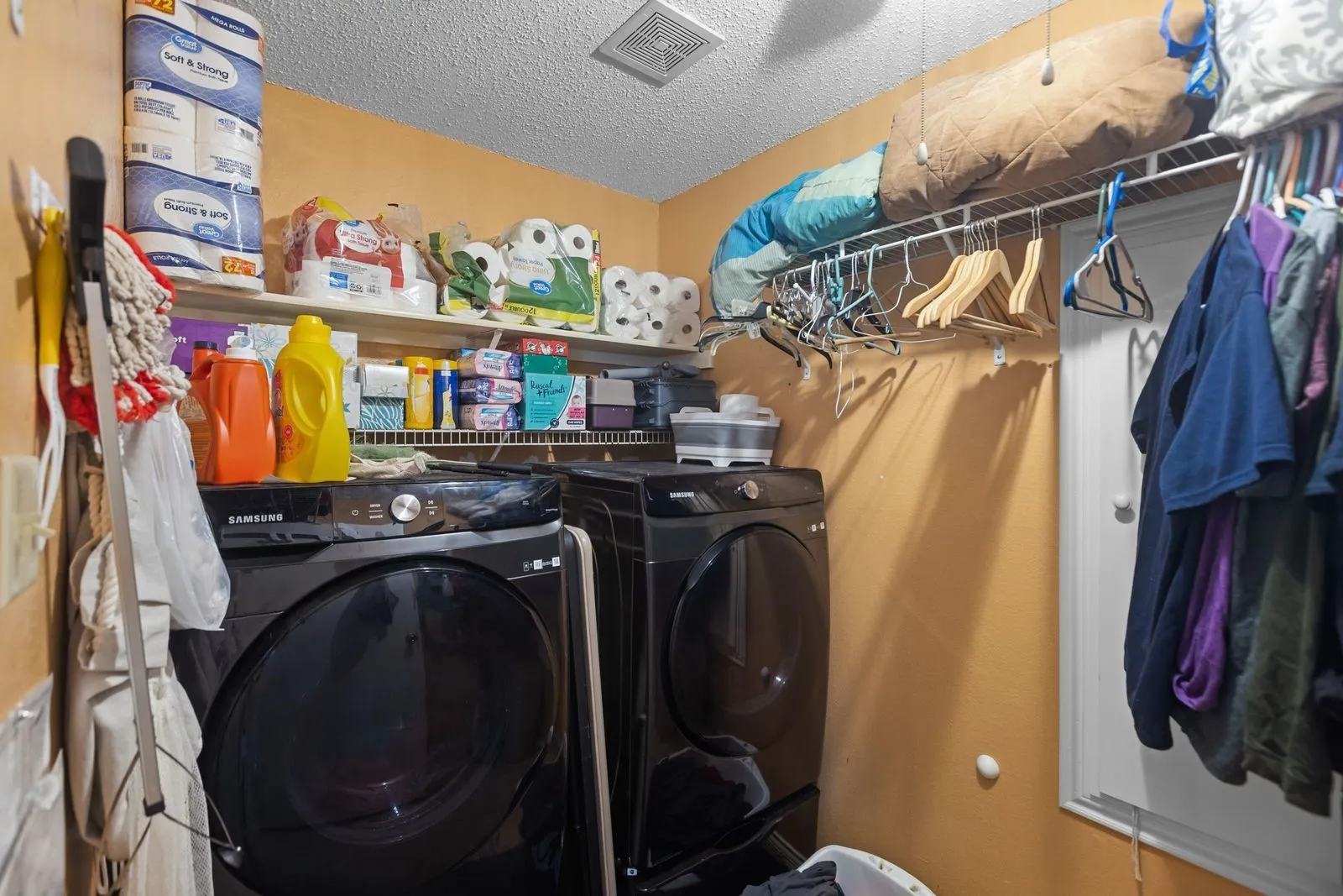 Laundry area with built-in wire shelving, overhead wire hanging rack, and a ceiling-mounted ventilation fan