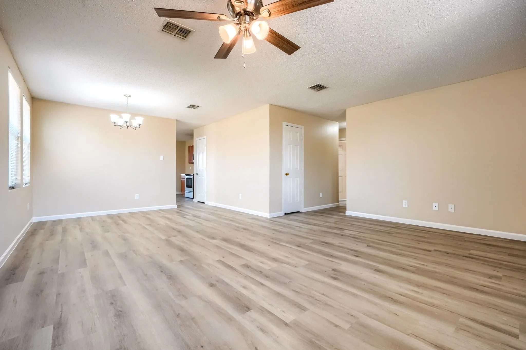 Spacious room featuring wood-finish flooring, neutral paint, a ceiling fan, and recessed lighting