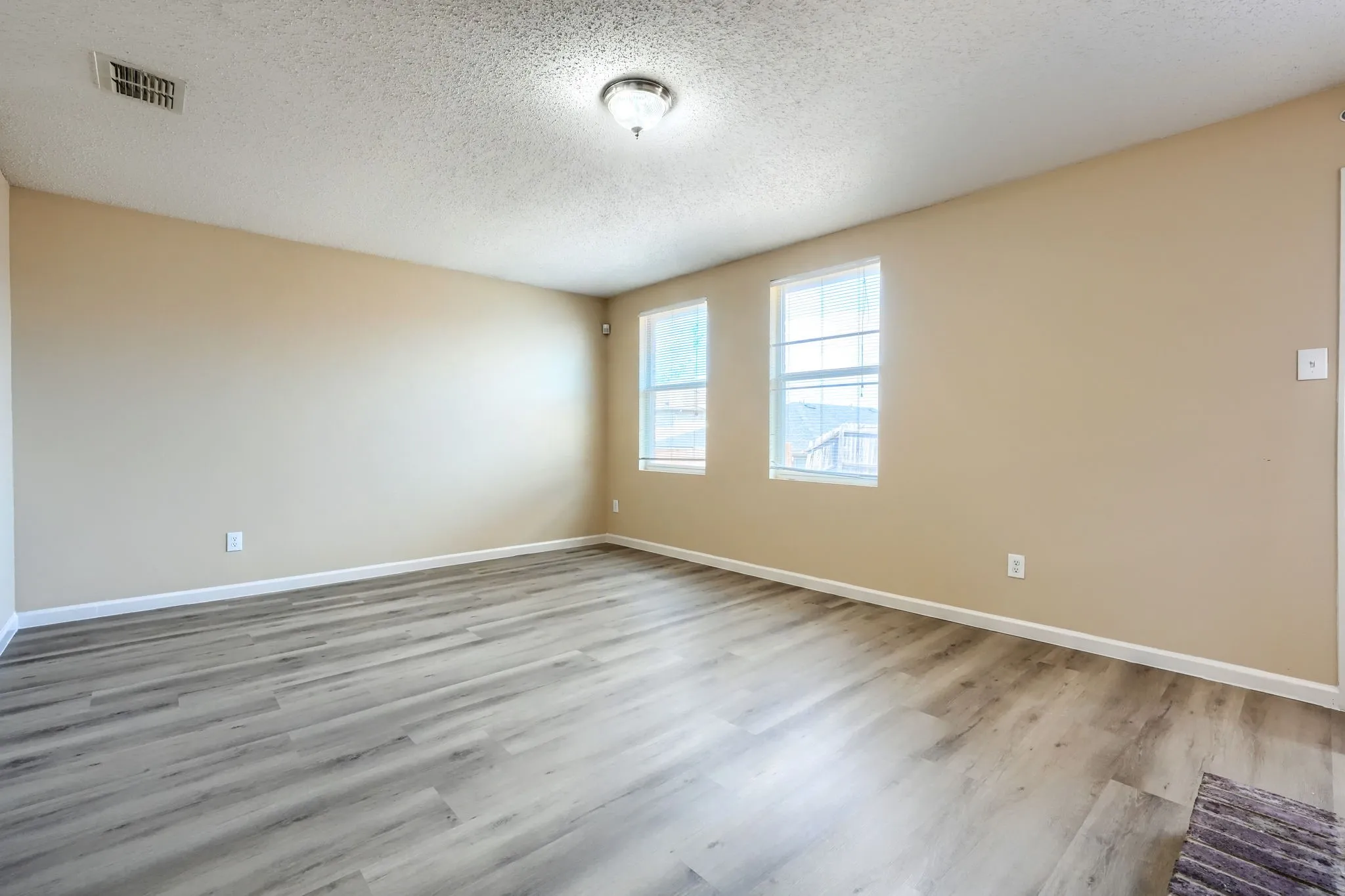 Neutral tone wall paint, wood-finish flooring, and recessed ceiling lighting