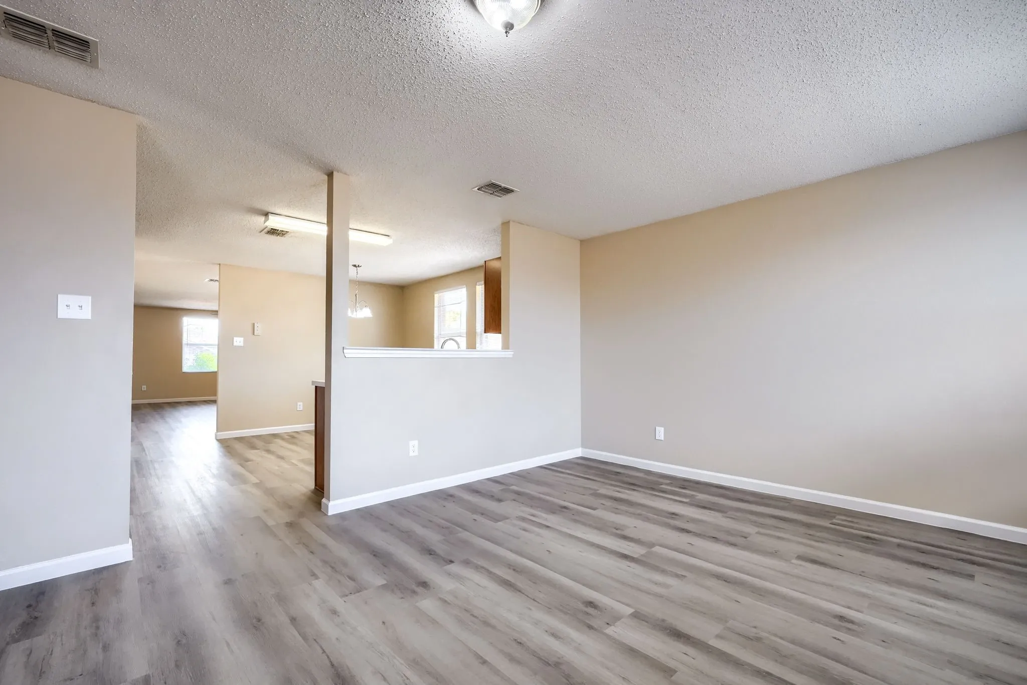 Wood-finish flooring throughout, light neutral wall tones, and recessed lighting