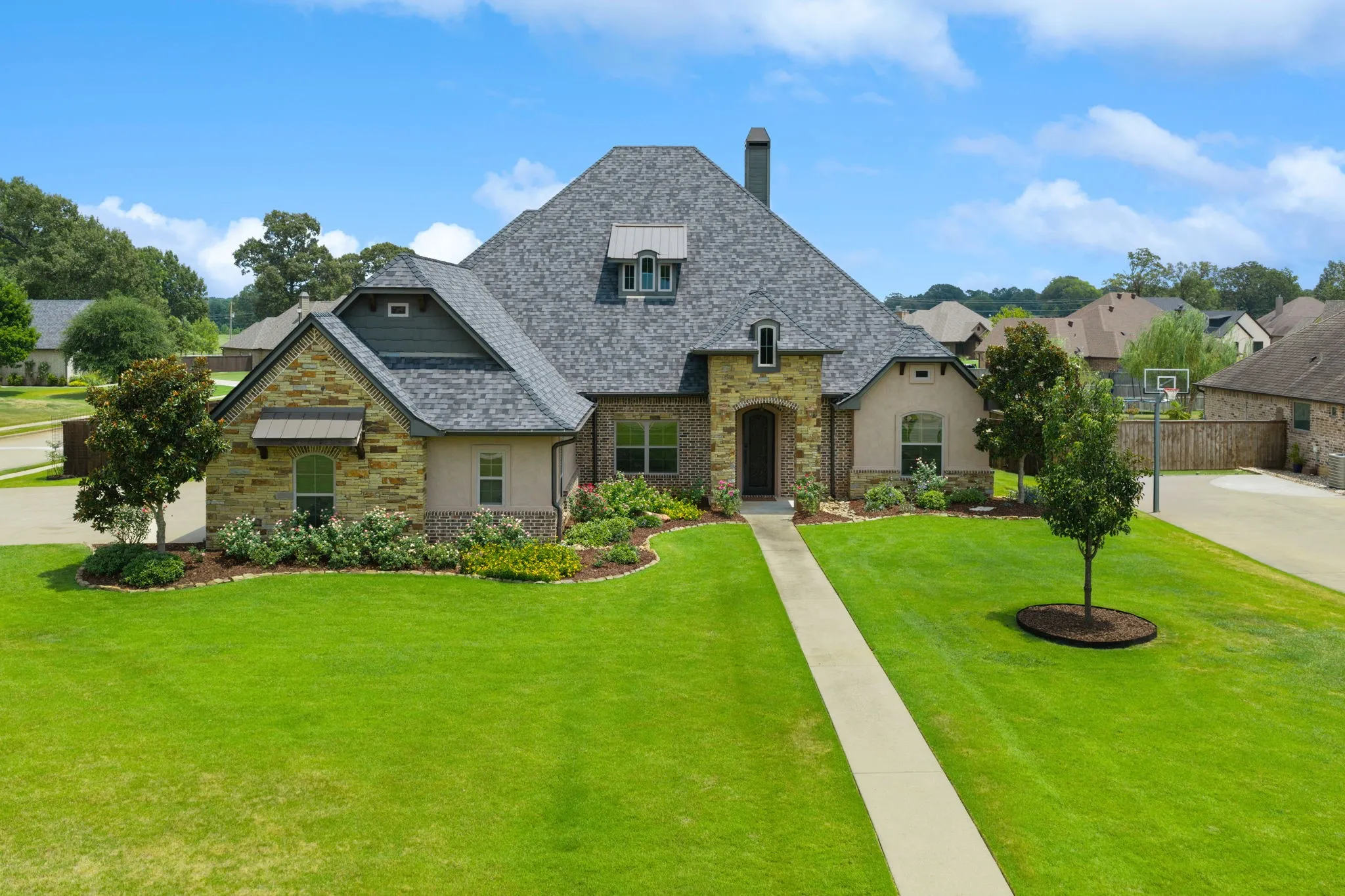 Elegant stone and stucco exterior with a steep pitched roof and multiple gables