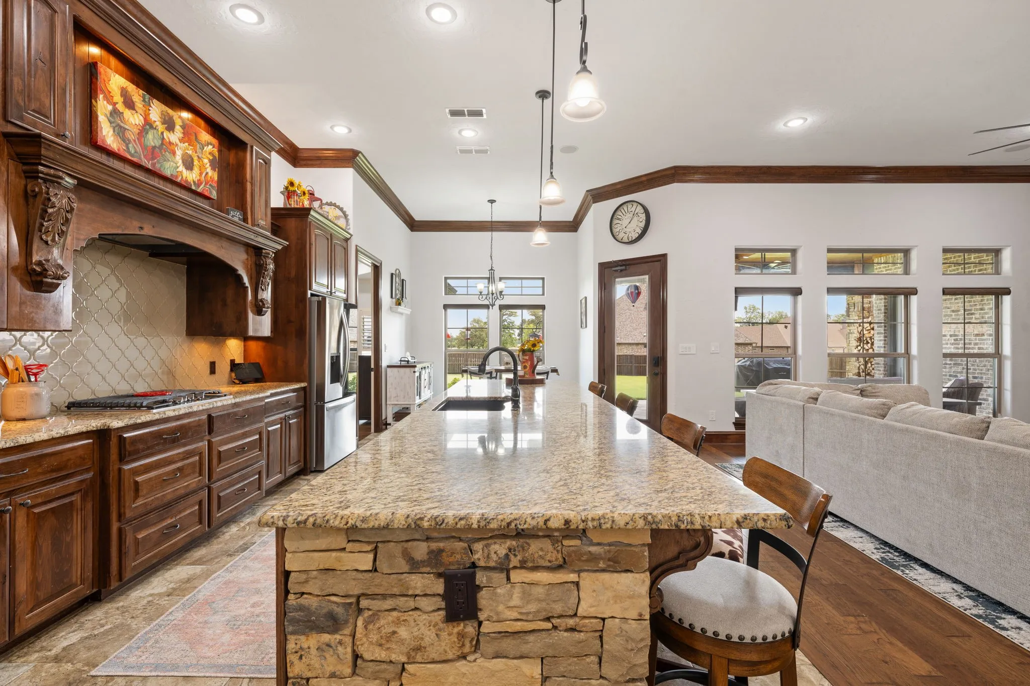 Expansive kitchen island featuring a stone base and granite countertop