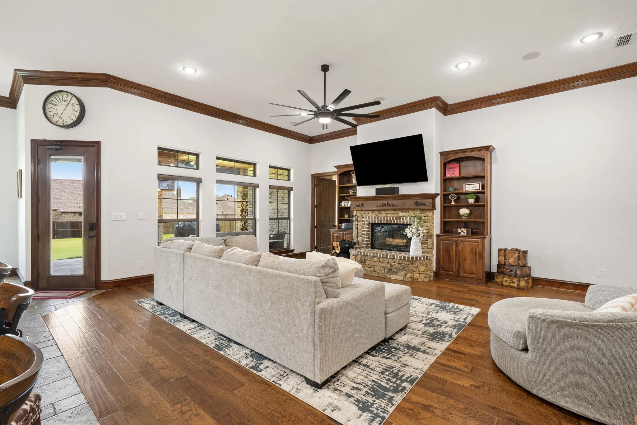 Spacious great room featuring hardwood flooring, coffered ceiling with ceiling fan, and recessed lighting