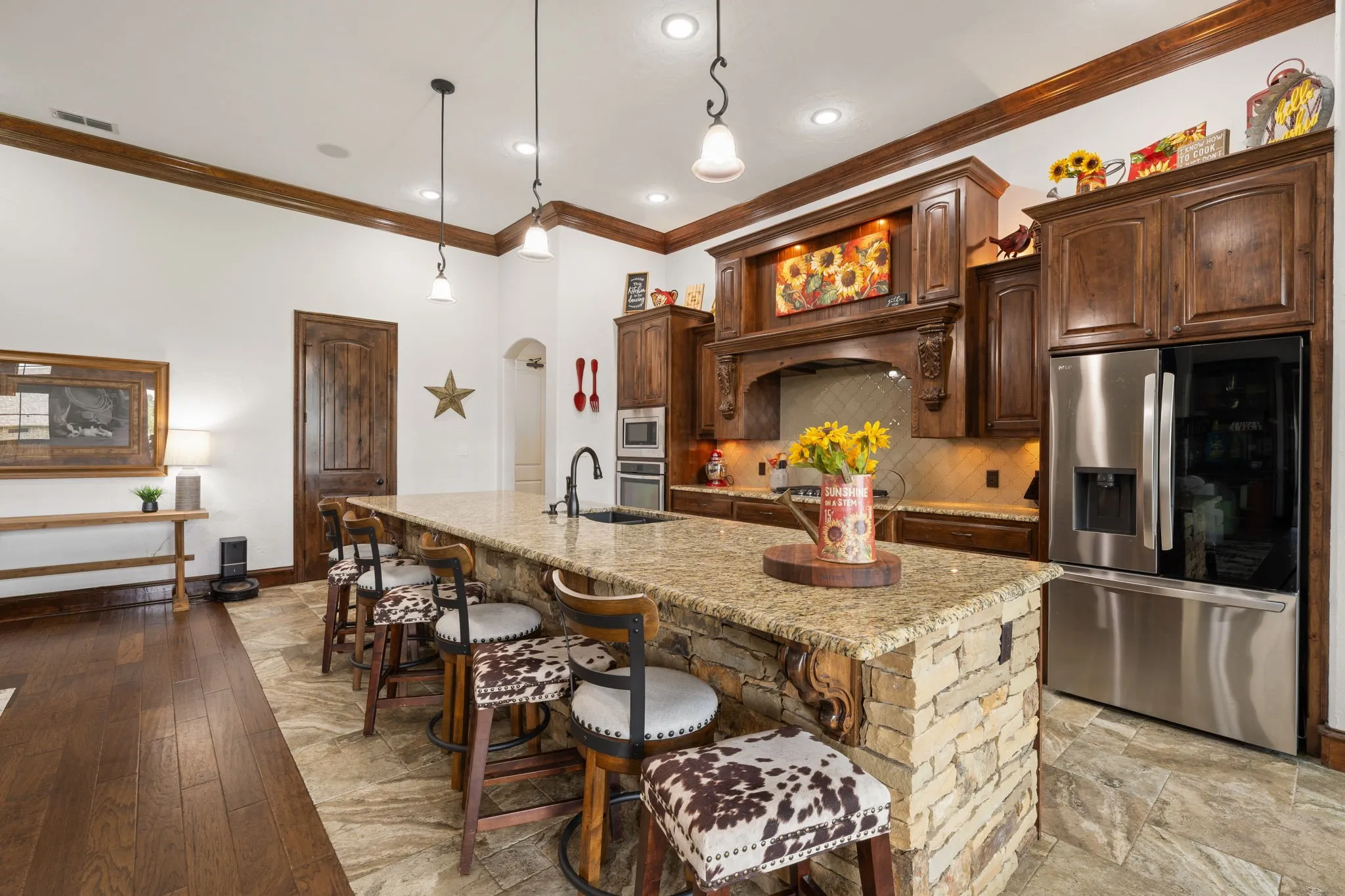 Expansive kitchen island with a stone base and light-toned countertop, complemented by dark wood-finish cabinetry
