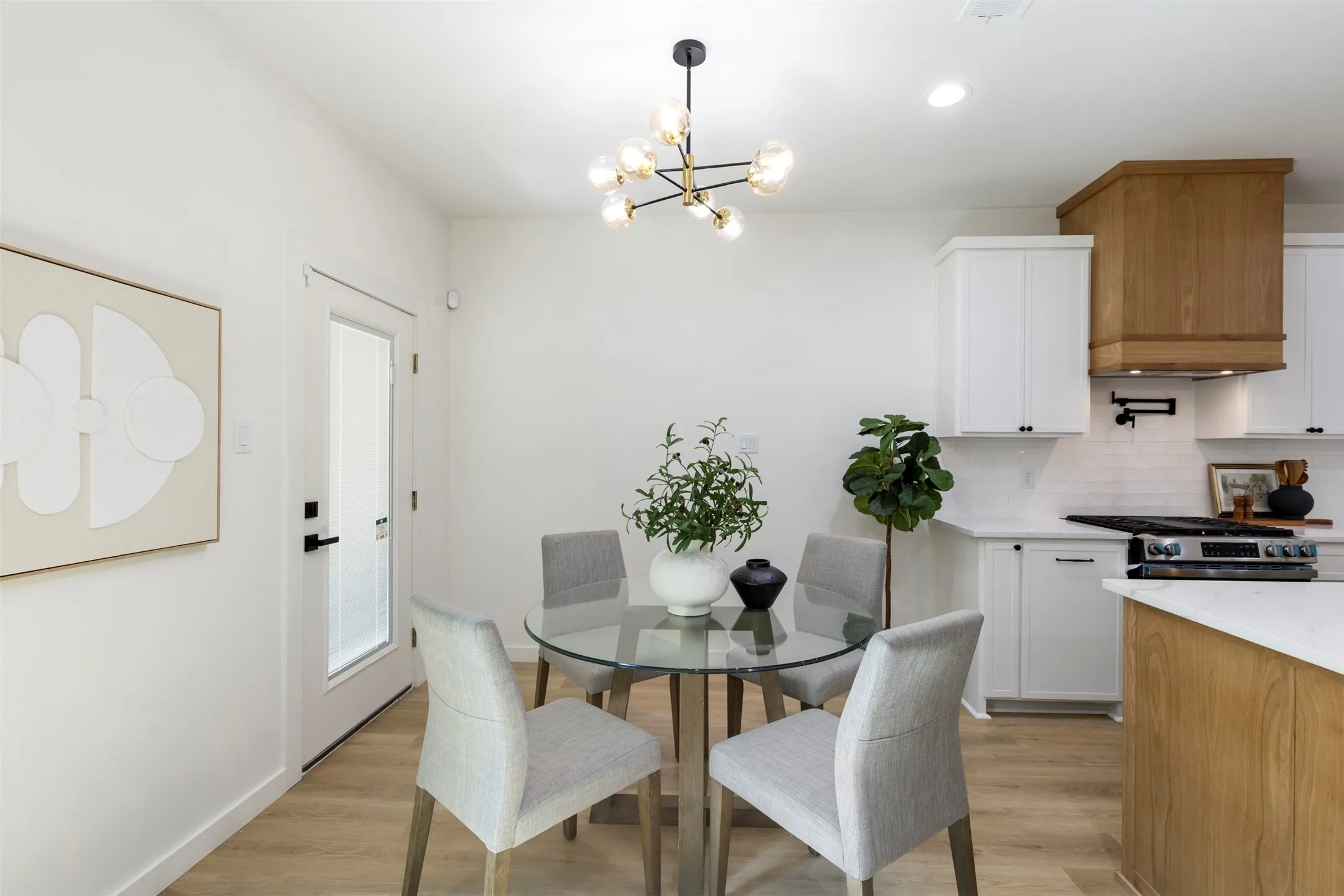 Wood-finish flooring, white walls, and a contemporary chandelier