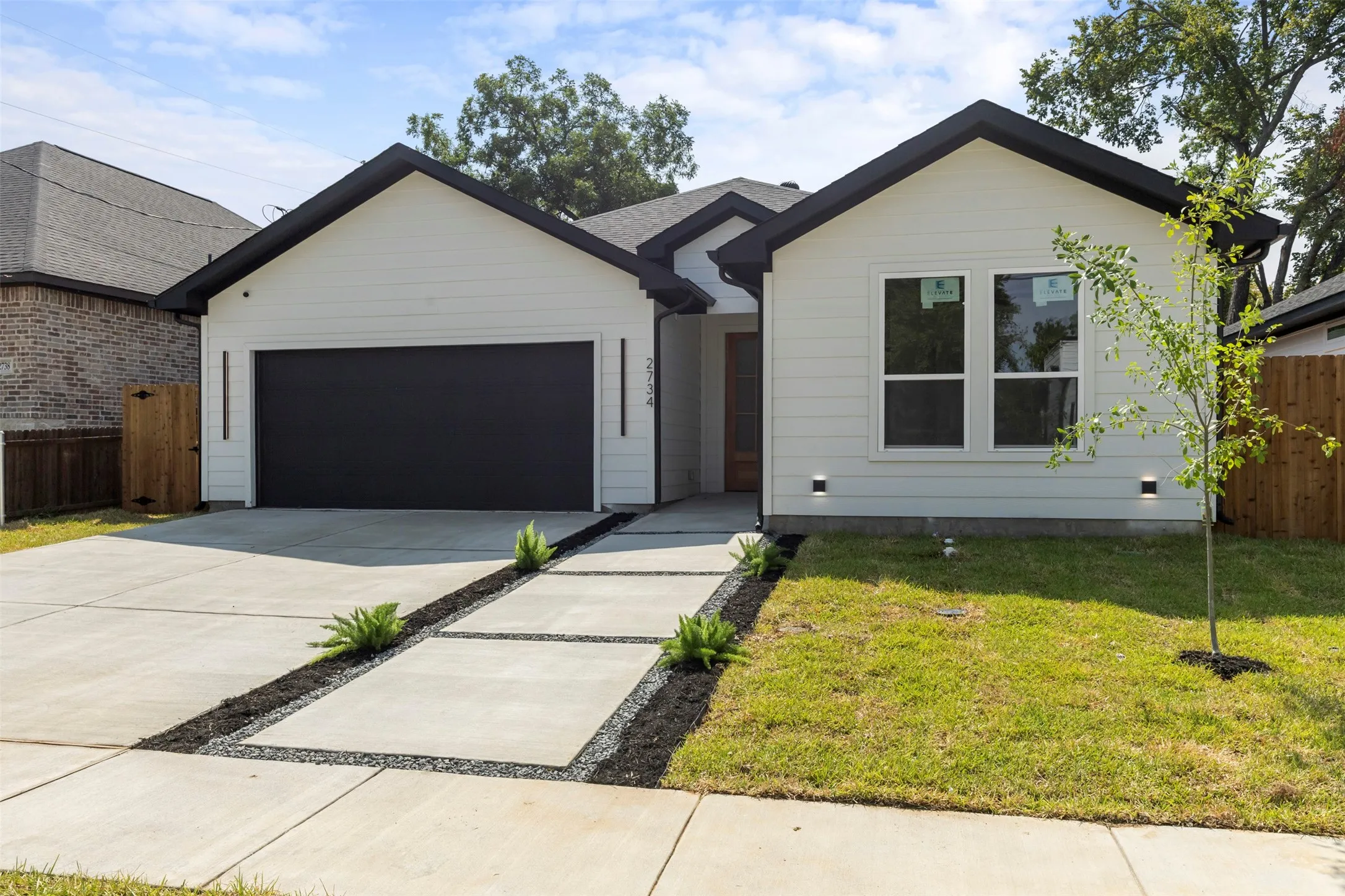 White siding exterior with a dark roof and trim