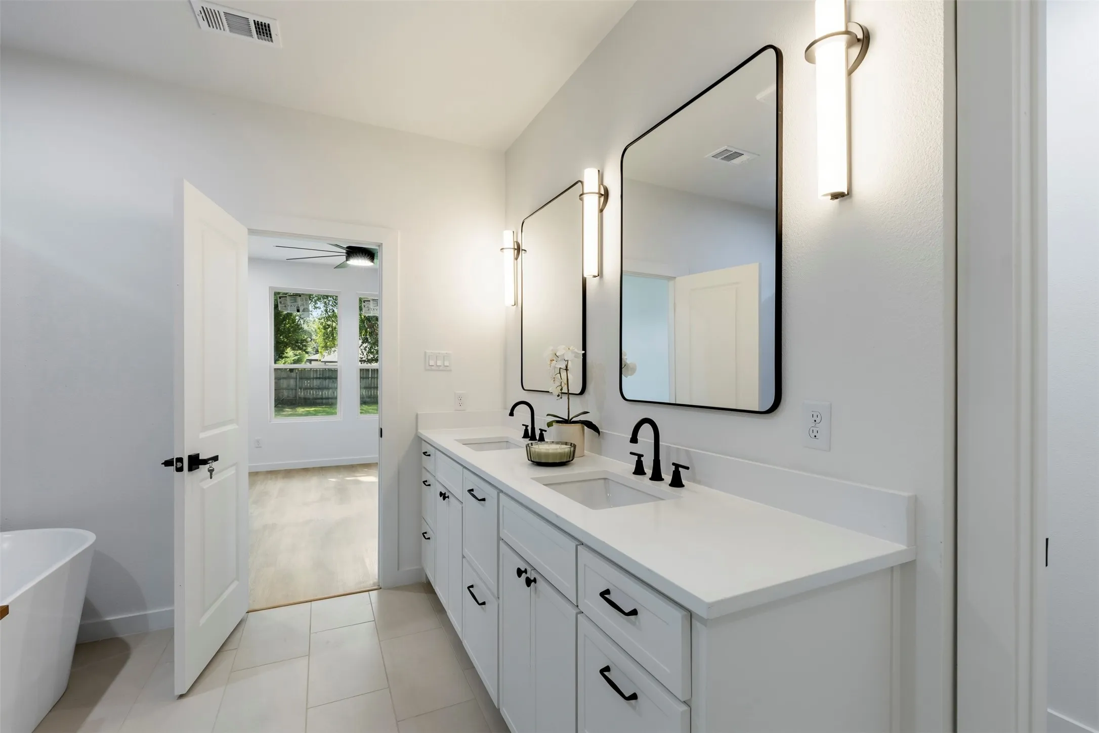 Dual vanity with white countertops, undermount sinks, and matte black fixtures