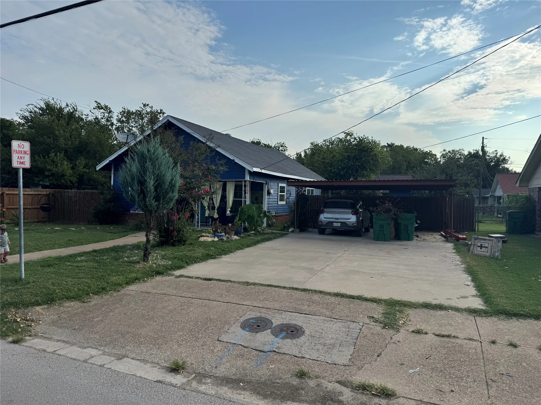 Single story home featuring concrete driveway and an attached carport