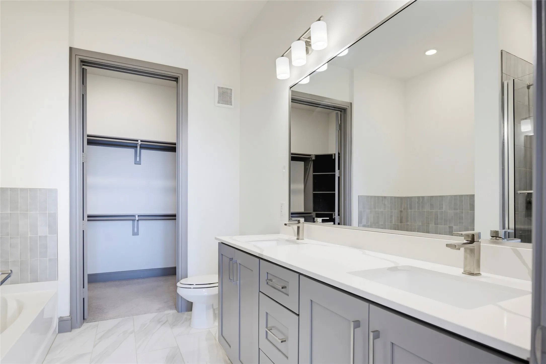 Dual vanity with white countertops, undermount sinks, and brushed nickel fixtures
