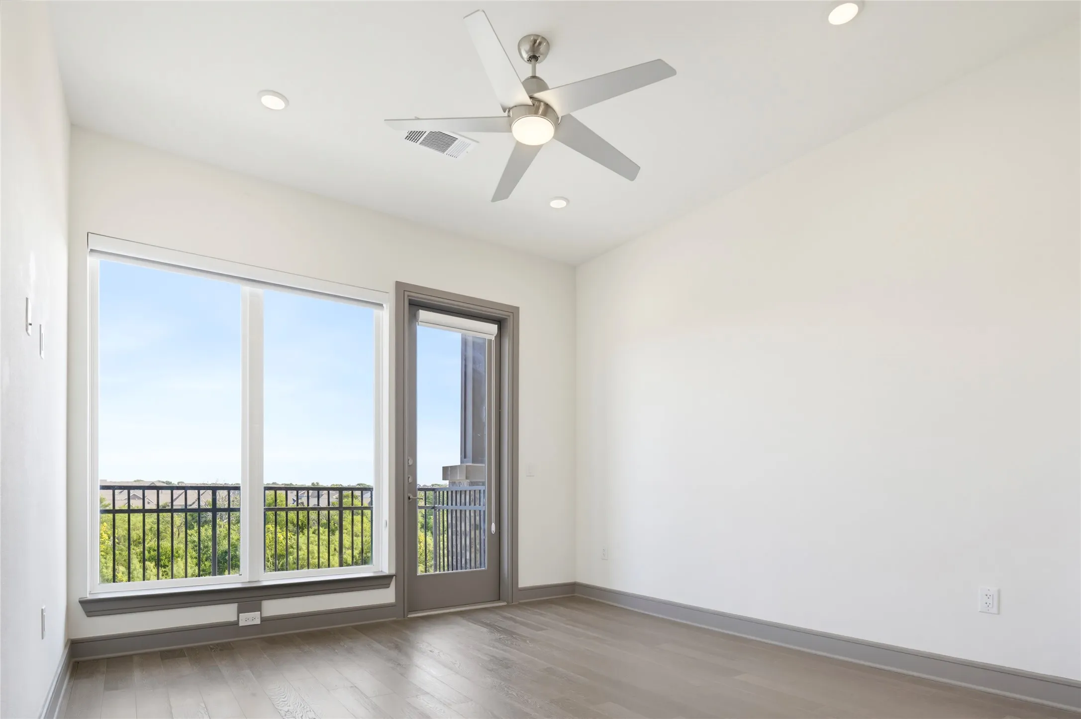 Recessed lighting, ceiling fan, wood-finish flooring, full-height window, and balcony access